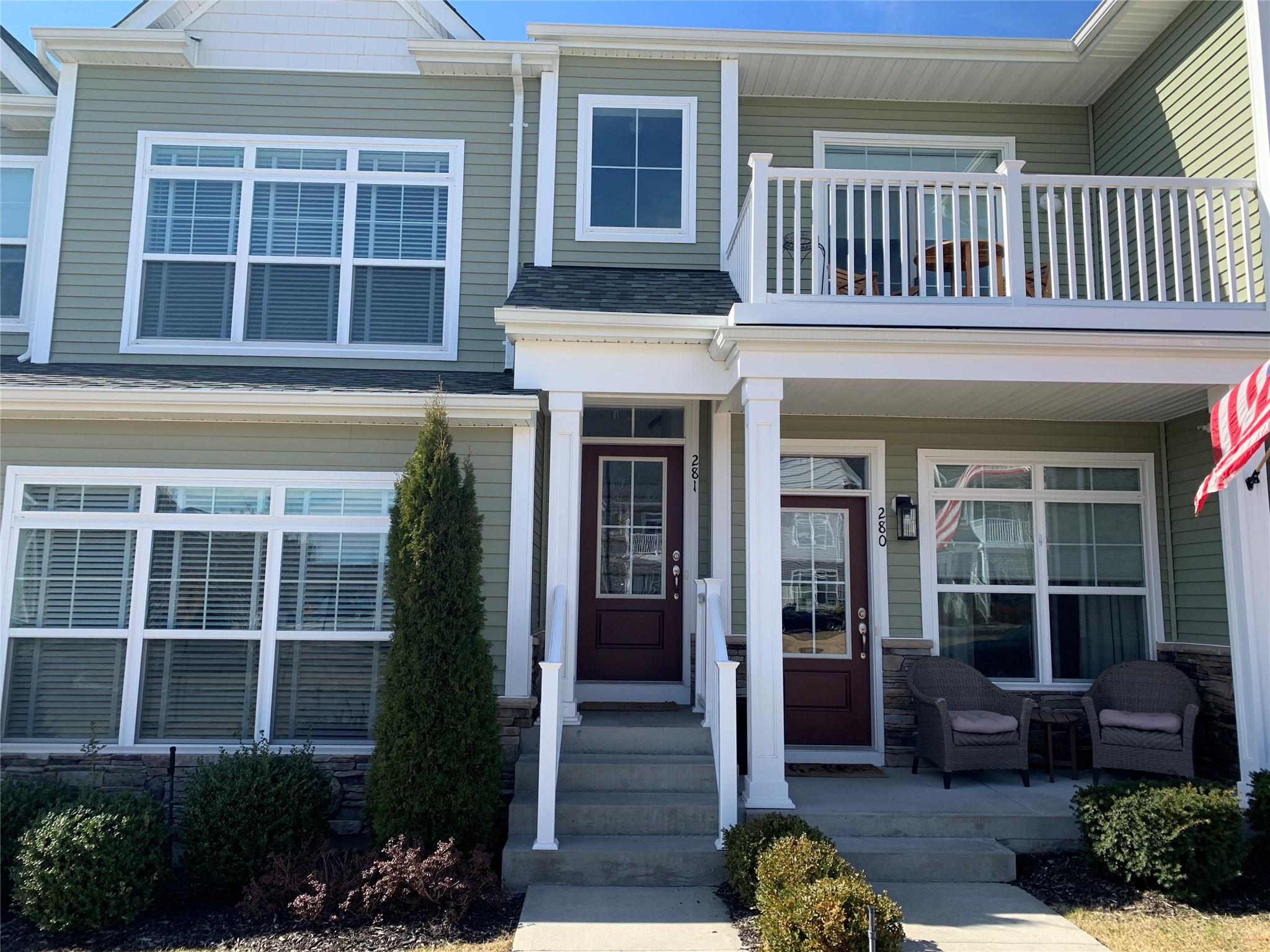 View of front of home featuring a porch, a balcony, and roof with shingles