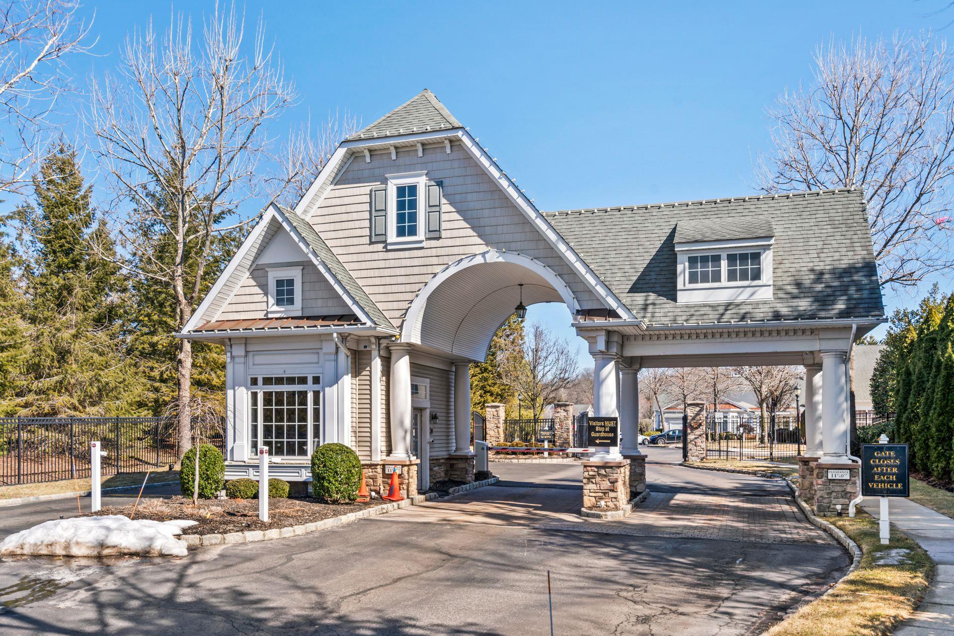 View of front of home featuring driveway, fence, and roof with shingles