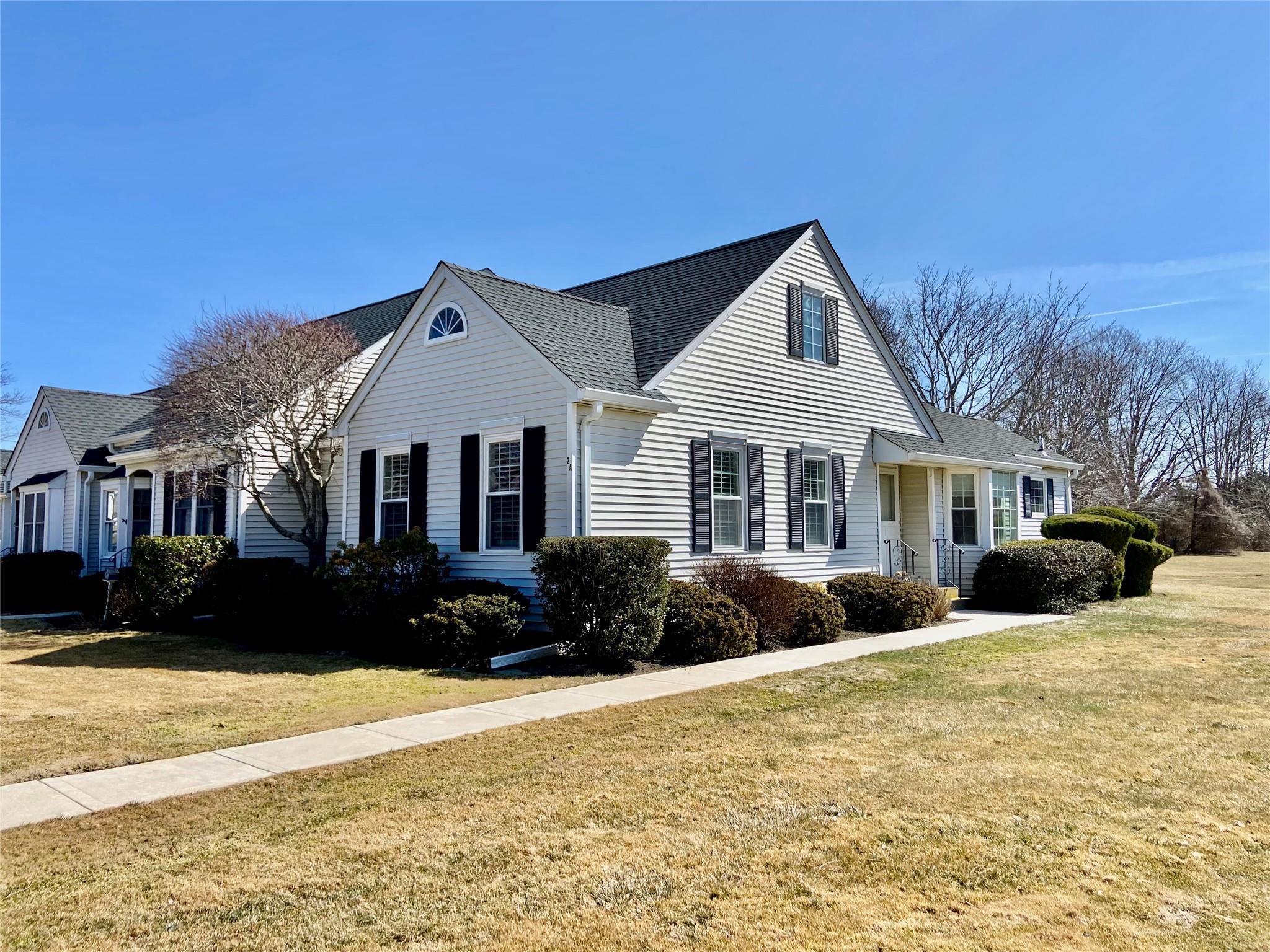 View of front of house featuring a front lawn and roof with shingles