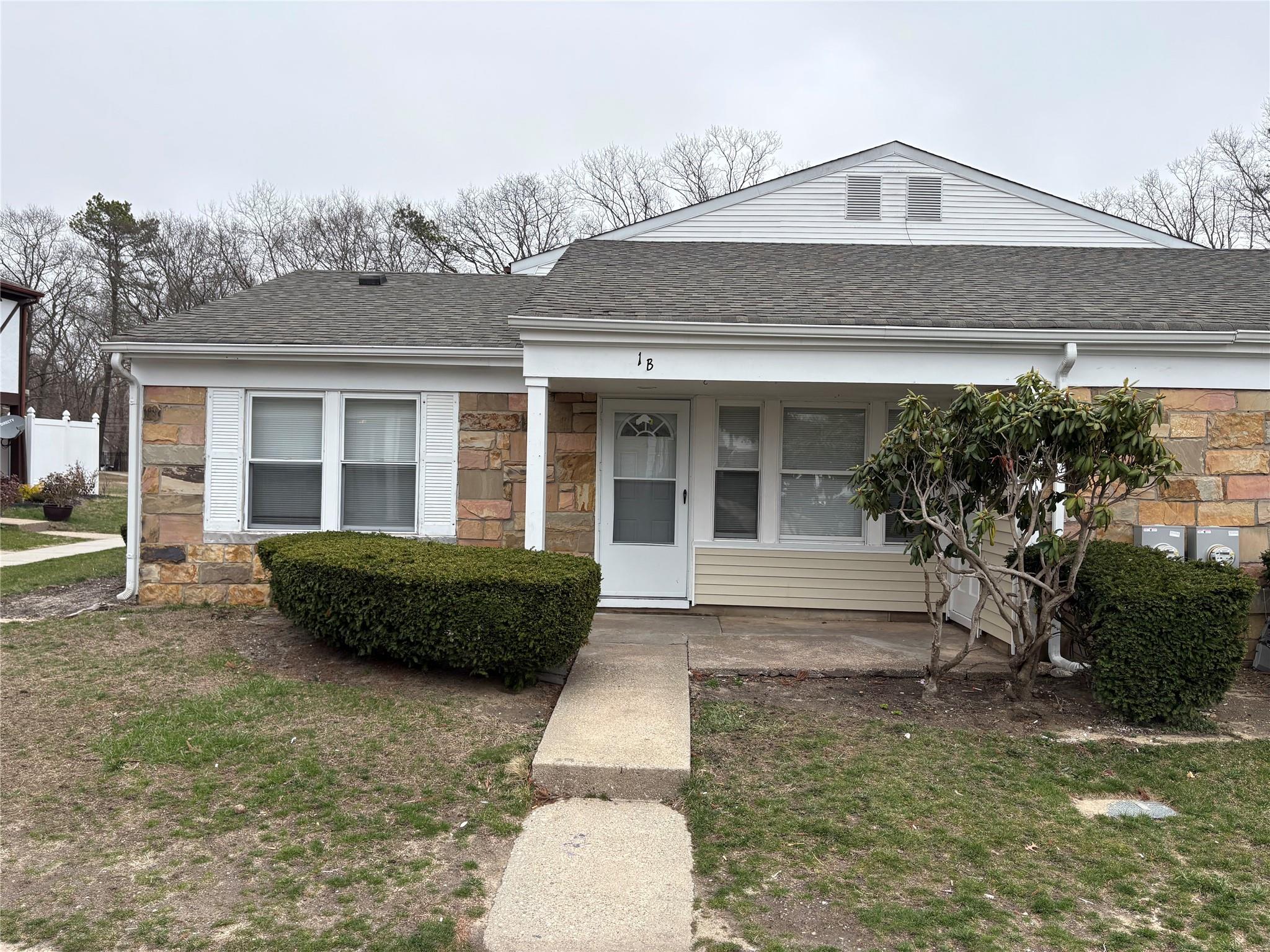 View of front of house with stone siding and a shingled roof