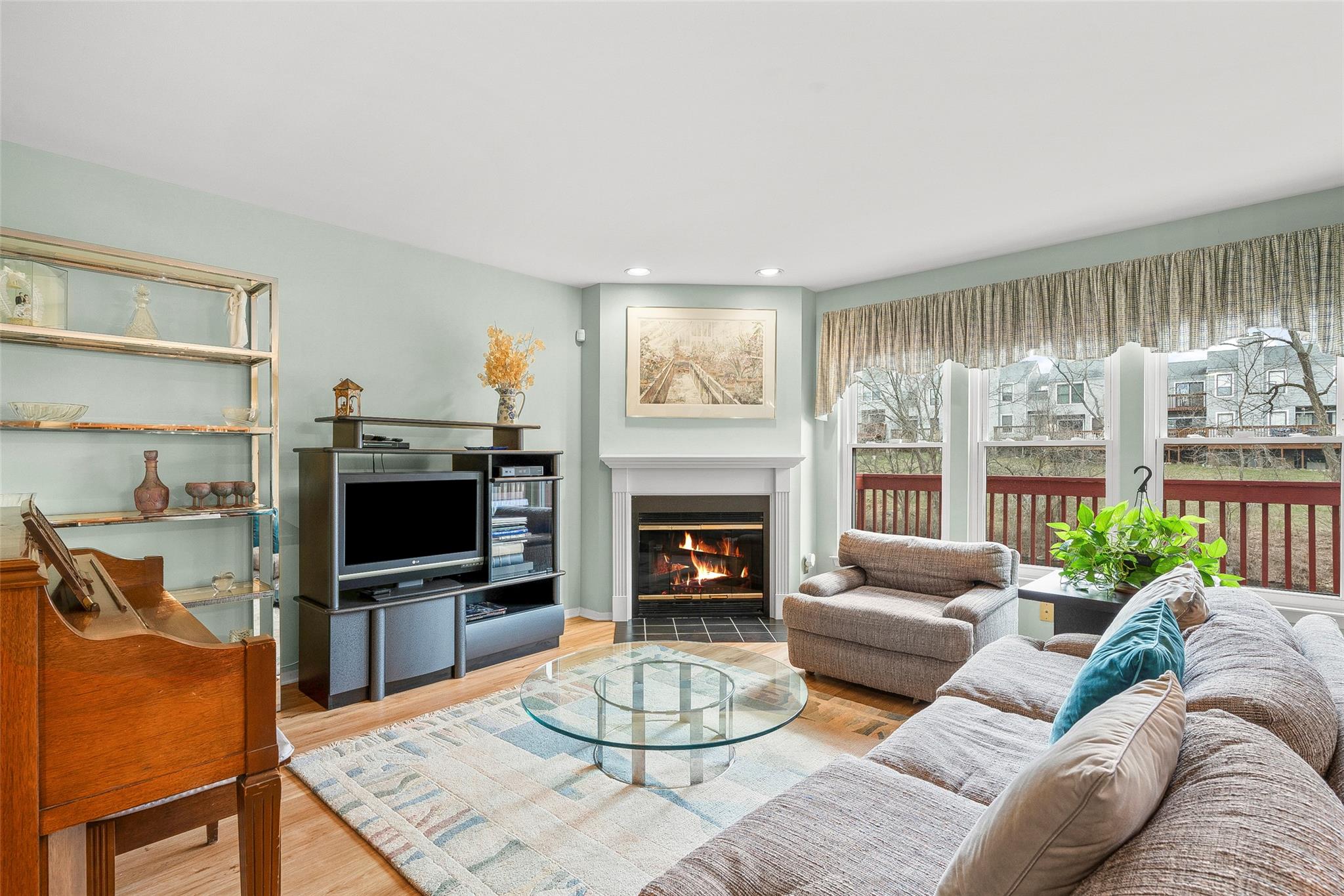 Living area with recessed lighting, a fireplace with flush hearth, and wood finished floors
