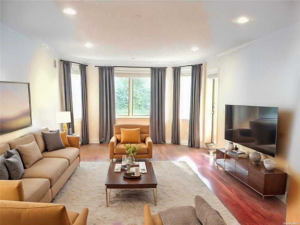 Living room featuring wood finished floors, ornamental molding, and recessed lighting