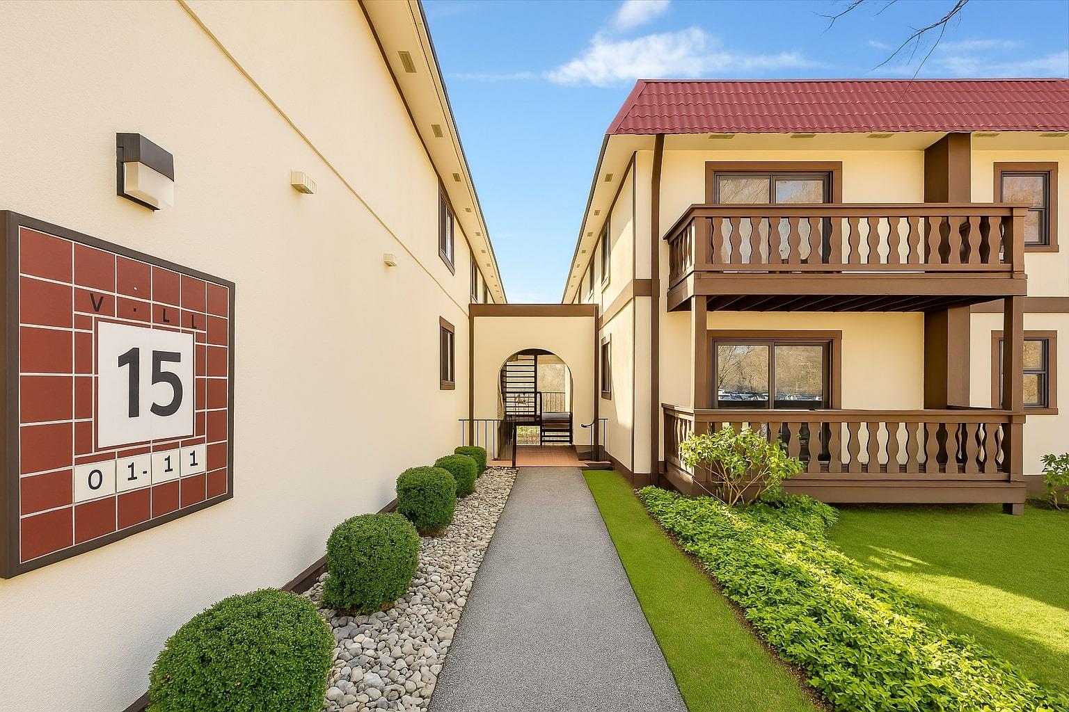 Doorway to property featuring a balcony, stucco siding, and a tiled roof