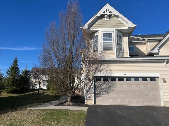 View of front of home with a garage and aphalt driveway