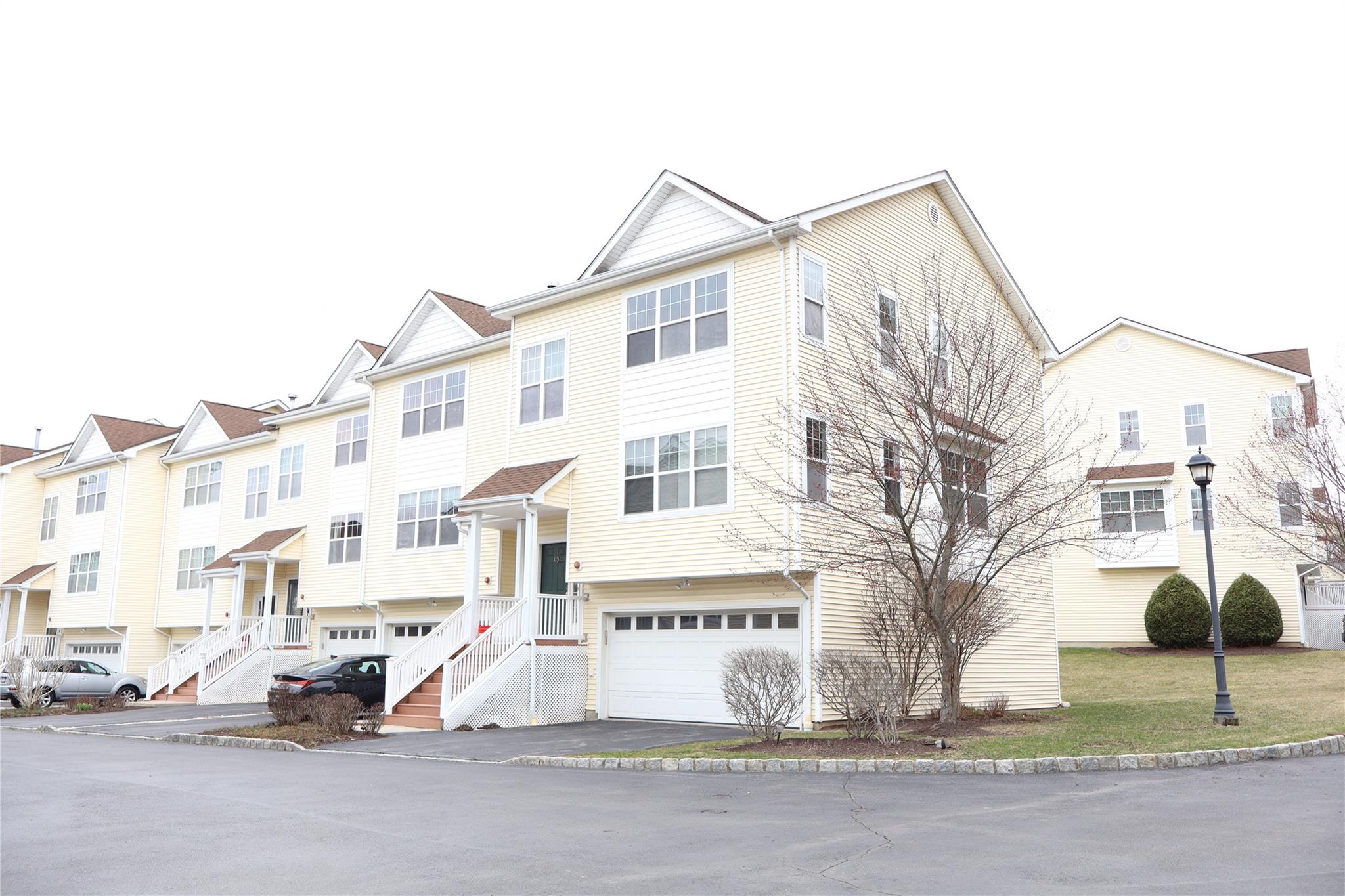View of front of home featuring driveway, an attached garage, and a residential view
