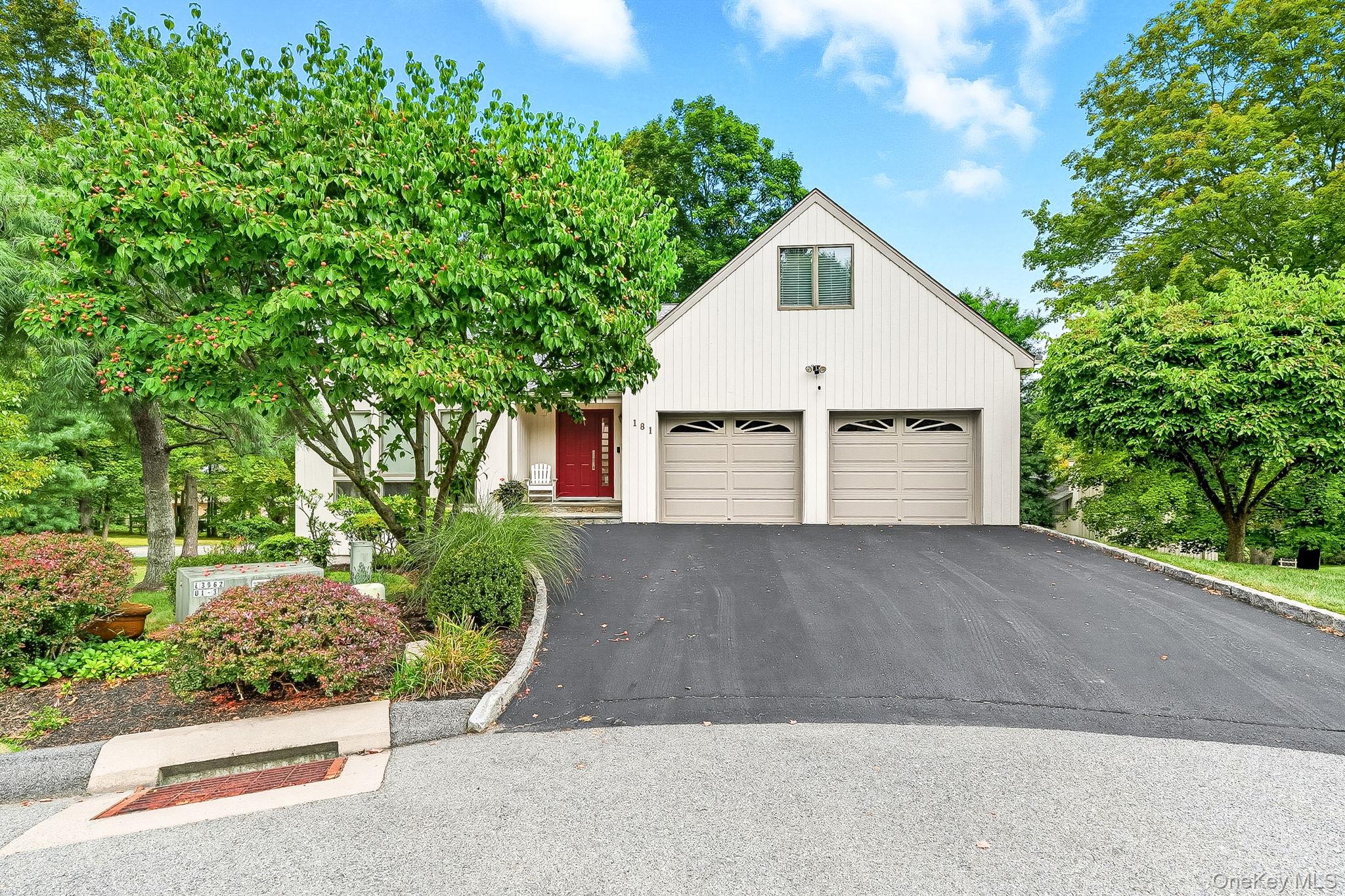 View of front of home featuring a garage and asphalt driveway