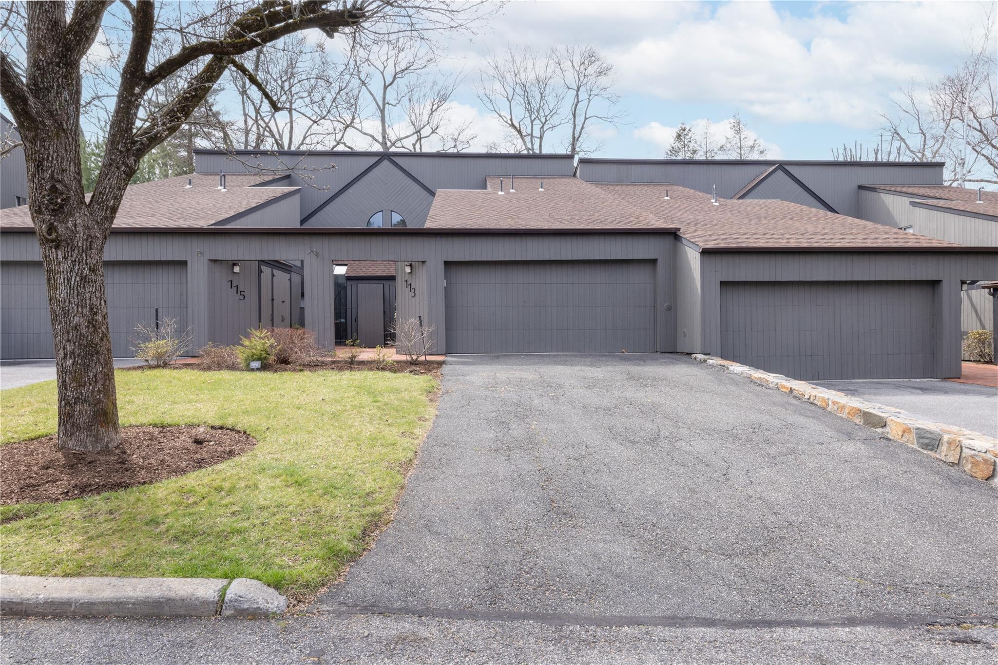 View of front of property featuring roof with shingles, a garage, and aphalt driveway