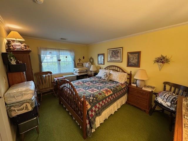 Carpeted bedroom featuring visible vents and crown molding