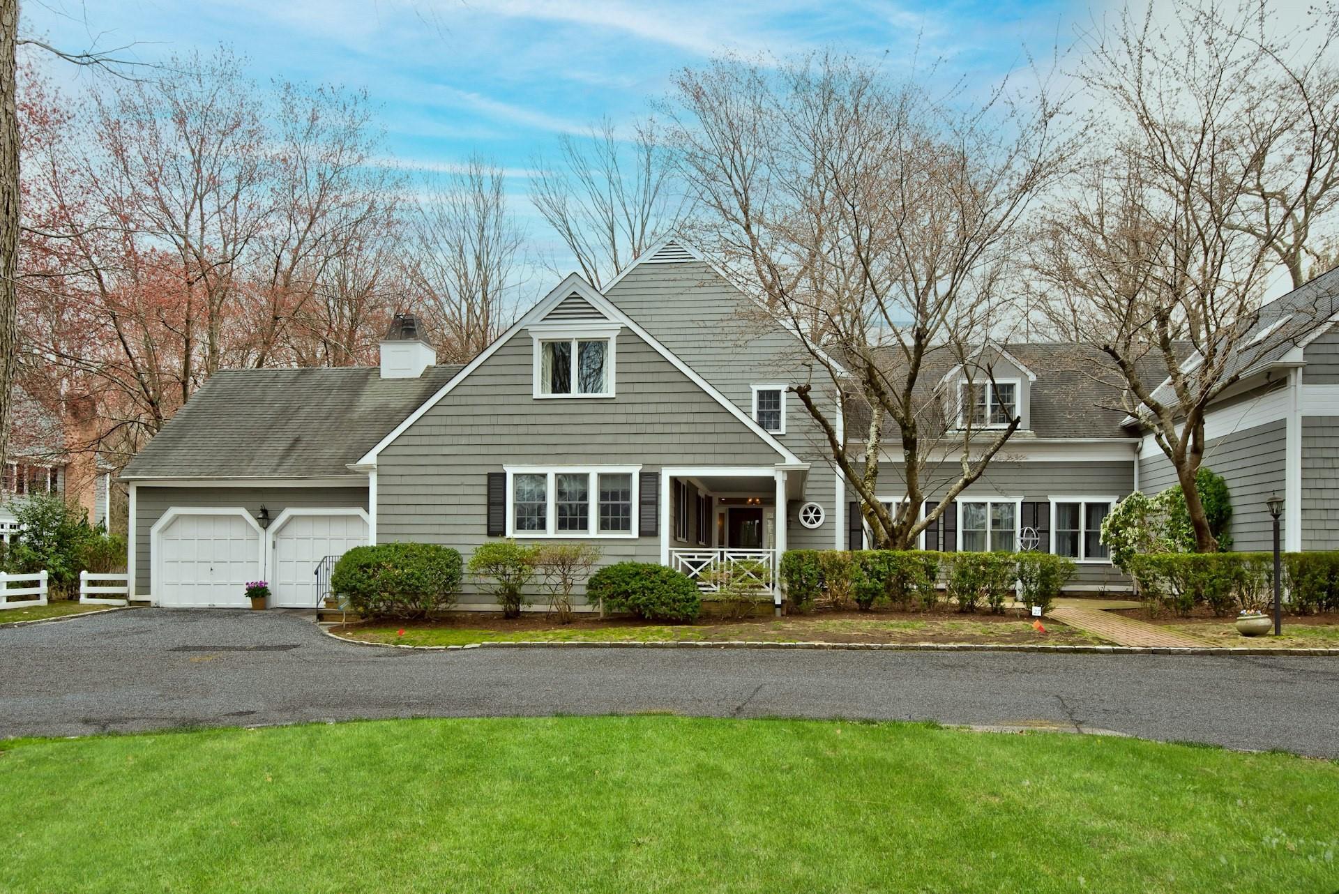 View of front facade featuring a front yard, aphalt driveway, and an attached garage
