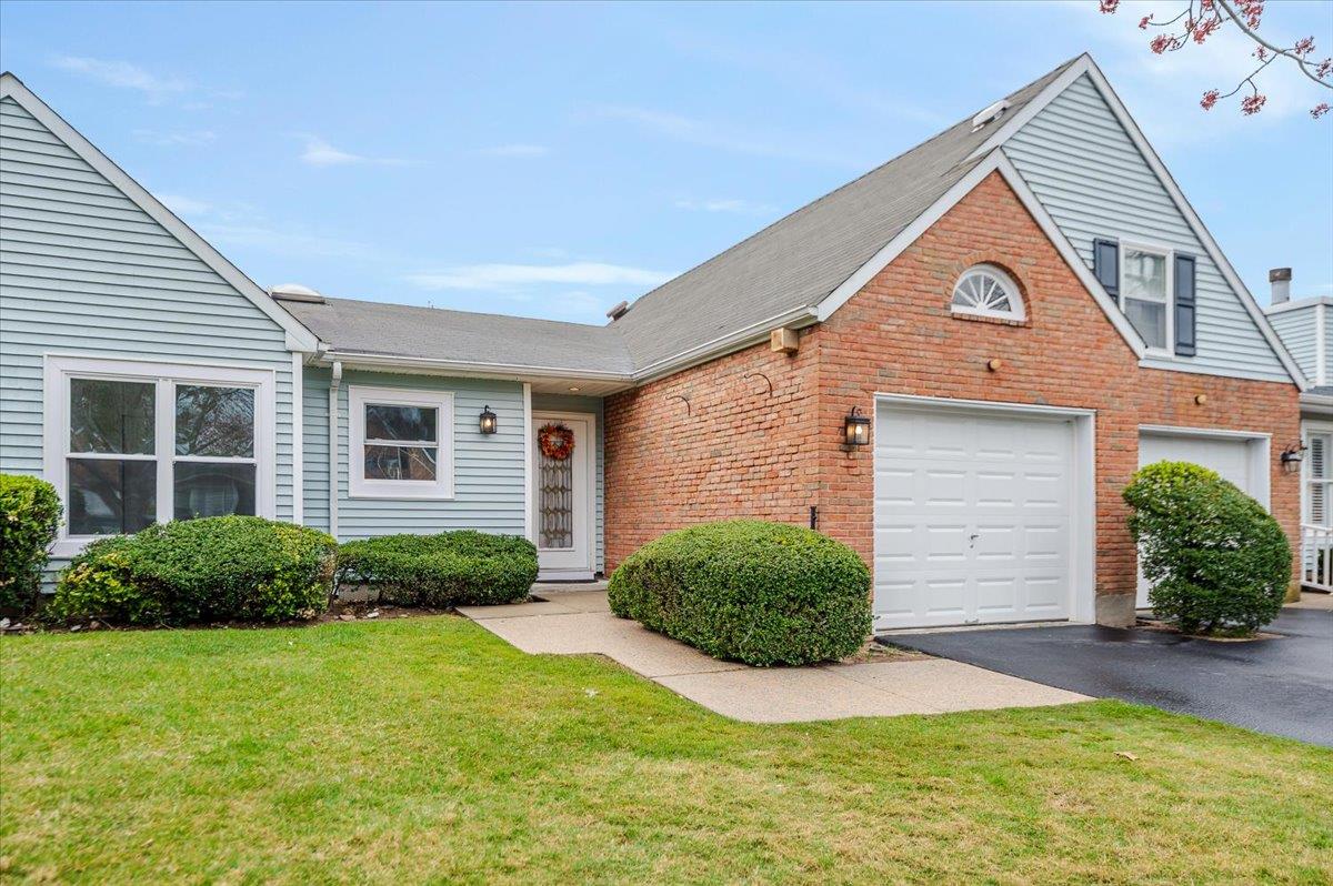View of front facade with a front lawn, a garage, and aphalt driveway