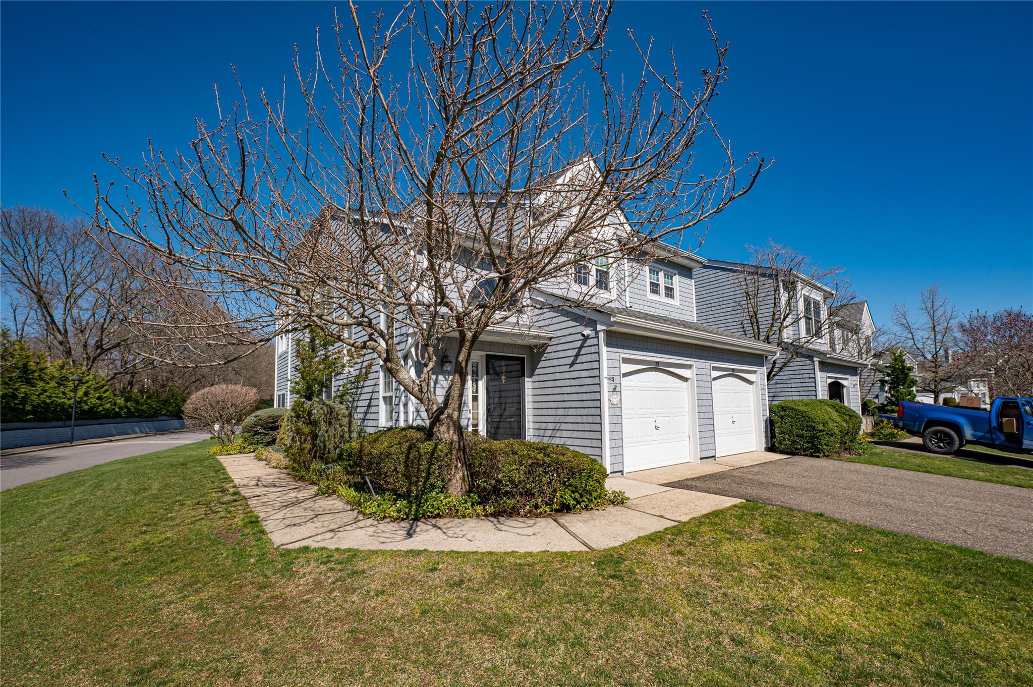 Traditional home with a front yard, a garage, and aphalt driveway