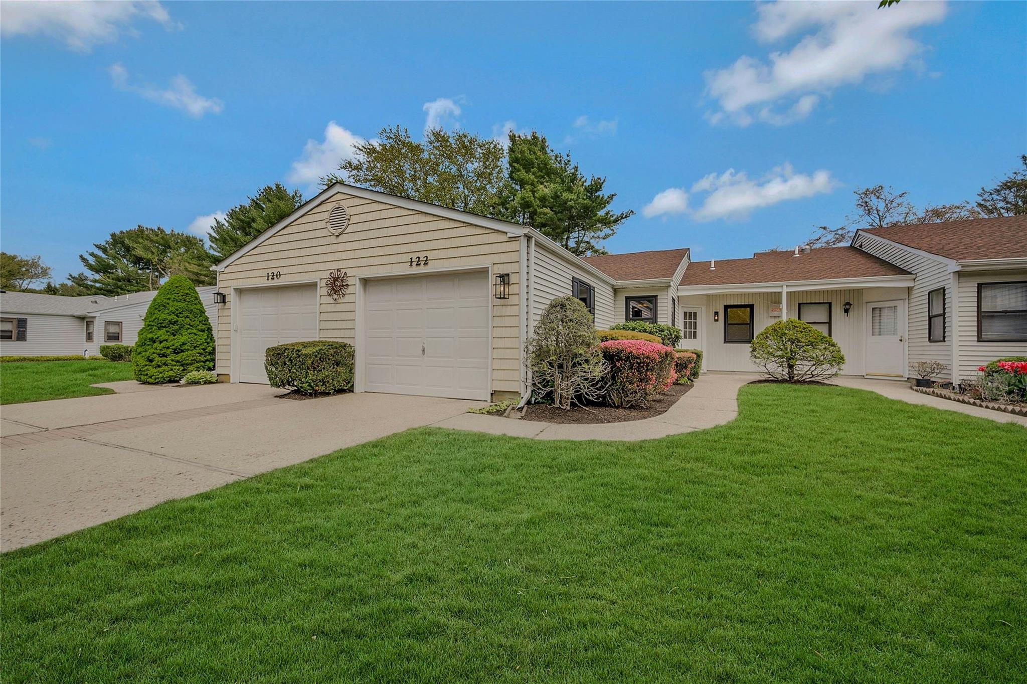 Ranch-style home featuring an attached garage, a front yard, and concrete driveway