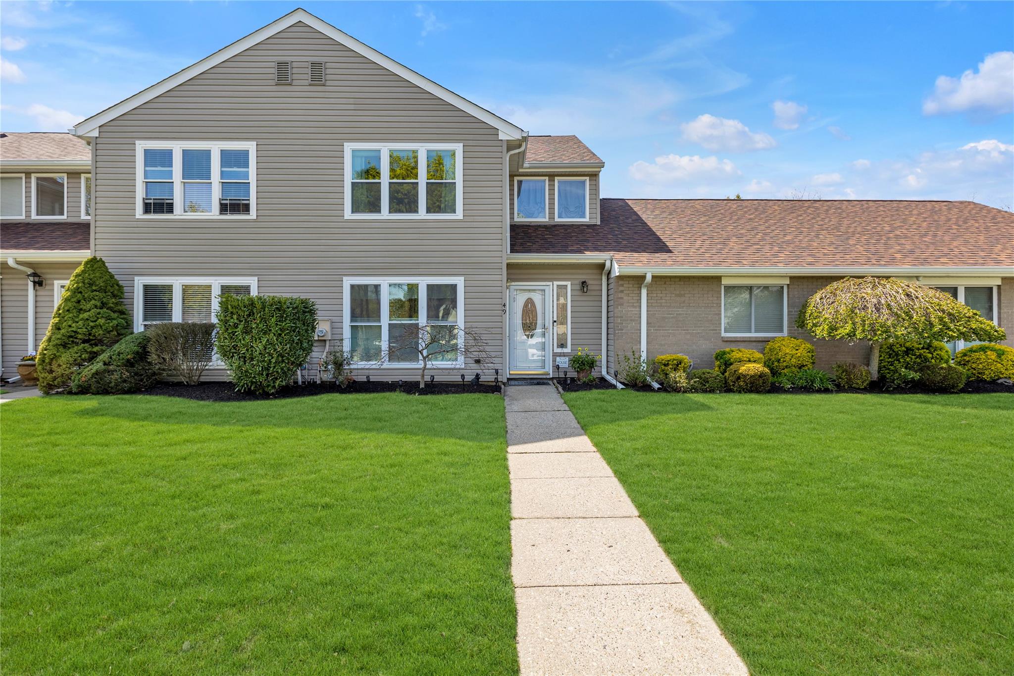 Traditional-style house with a front lawn and roof with shingles