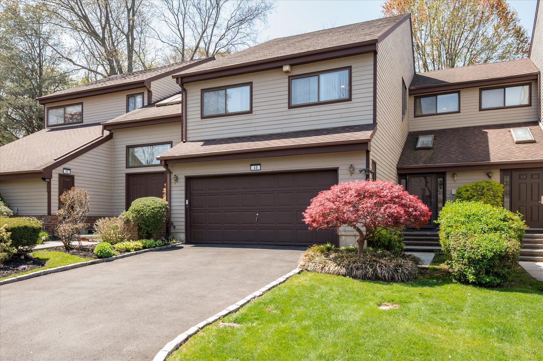 View of front of home with an attached garage, driveway, and roof with shingles