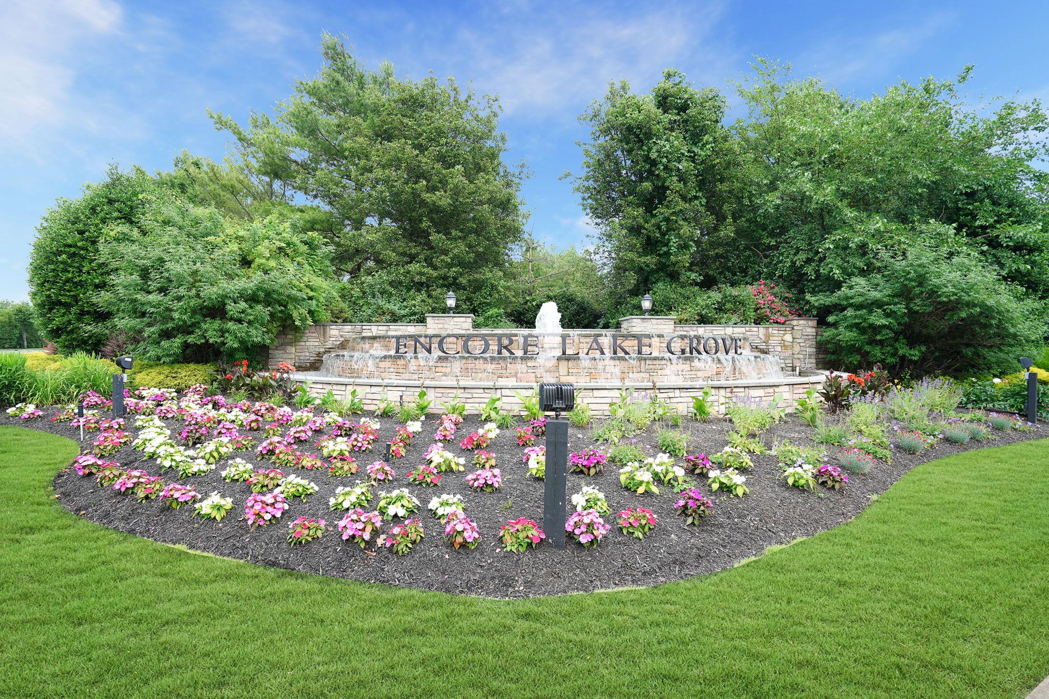 Community sign featuring fountain and lawn