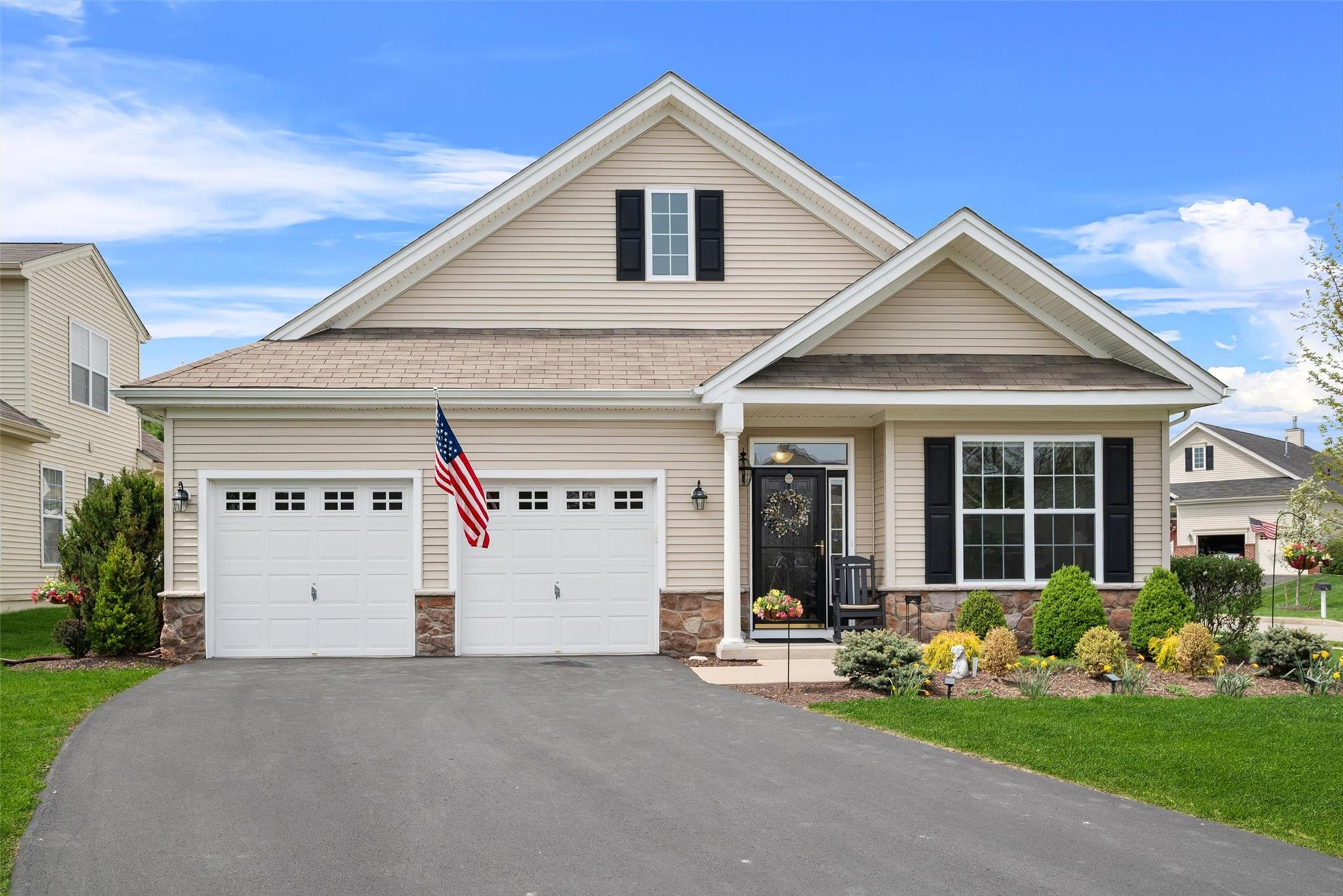 Craftsman inspired home featuring a garage, a shingled roof, driveway, and stone siding
