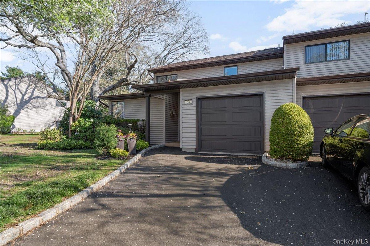 View of front facade featuring an attached garage and driveway