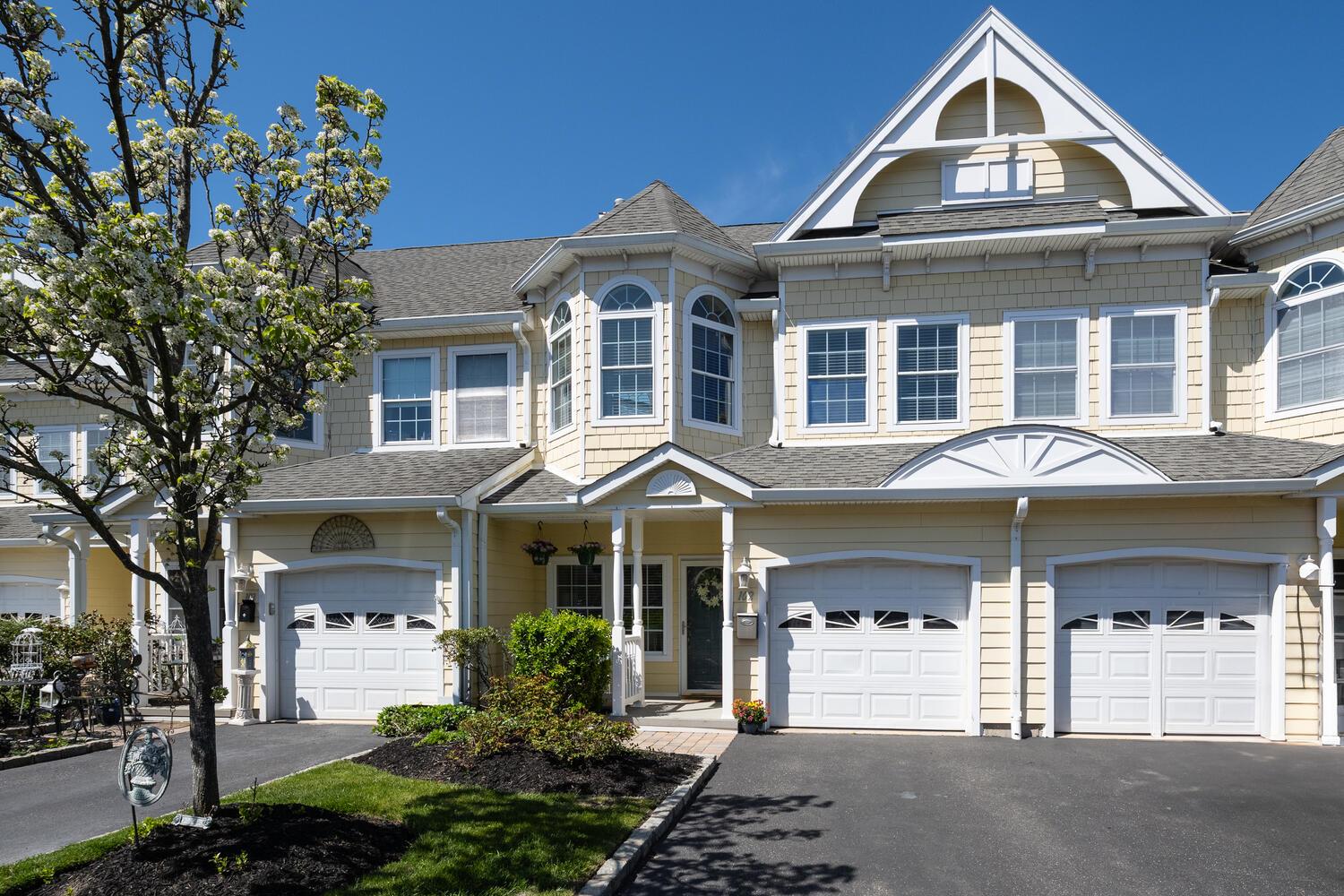 View of front of property featuring roof with shingles, an attached garage, and aphalt driveway