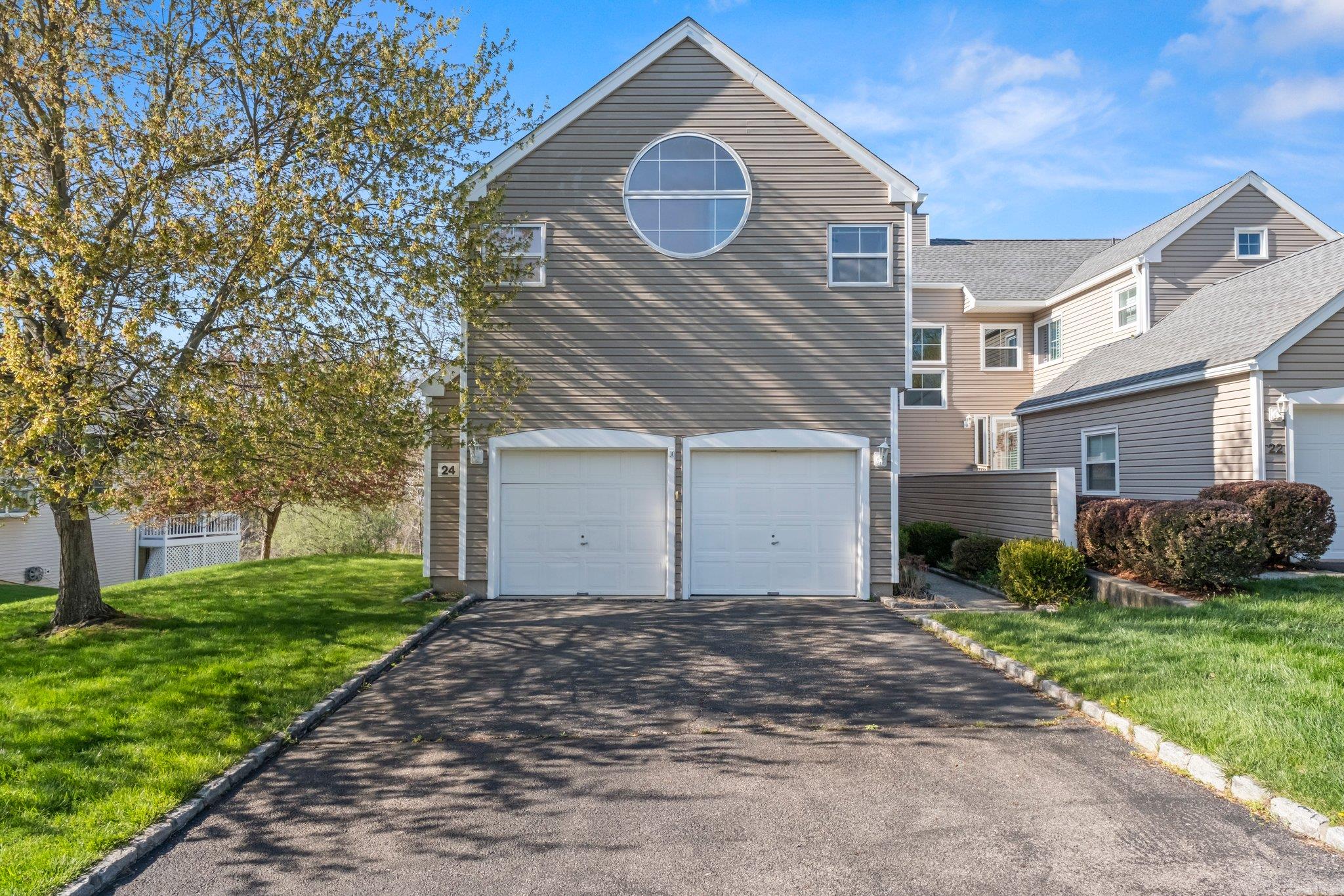 View of front of home featuring a garage, a front lawn, and aphalt driveway