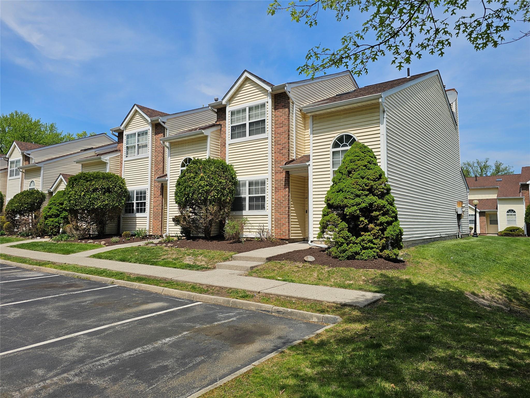 Multi unit property with a front lawn and uncovered parking