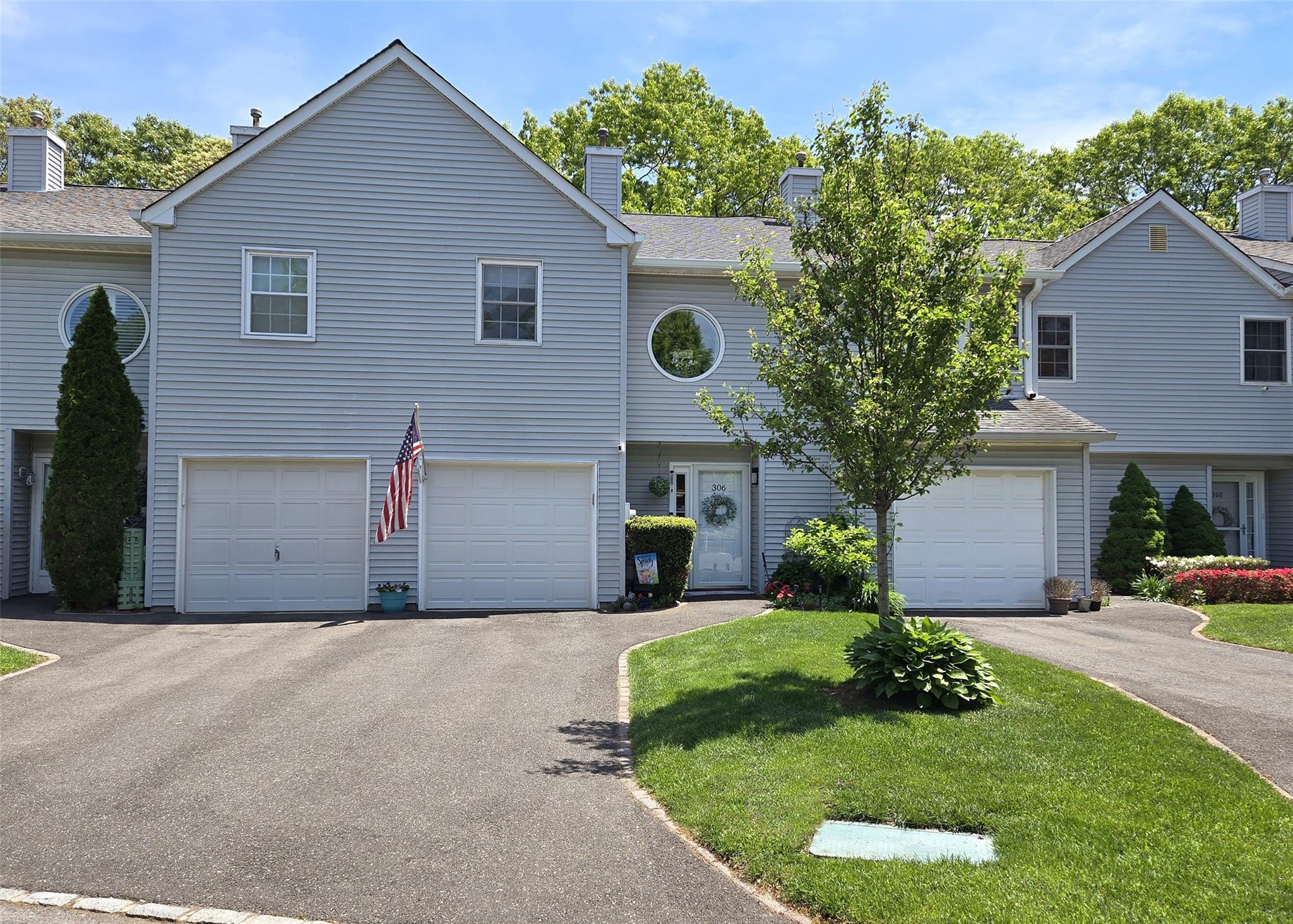 View of front facade with a chimney, driveway, and a front lawn