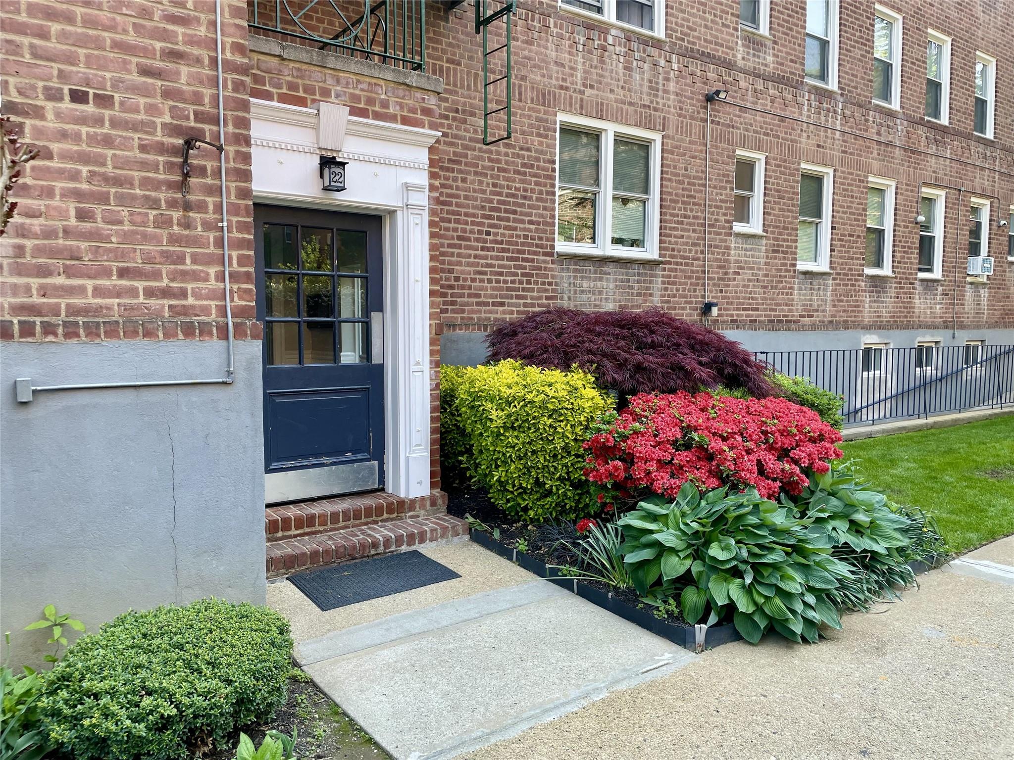 Entrance to property featuring brick siding and fence