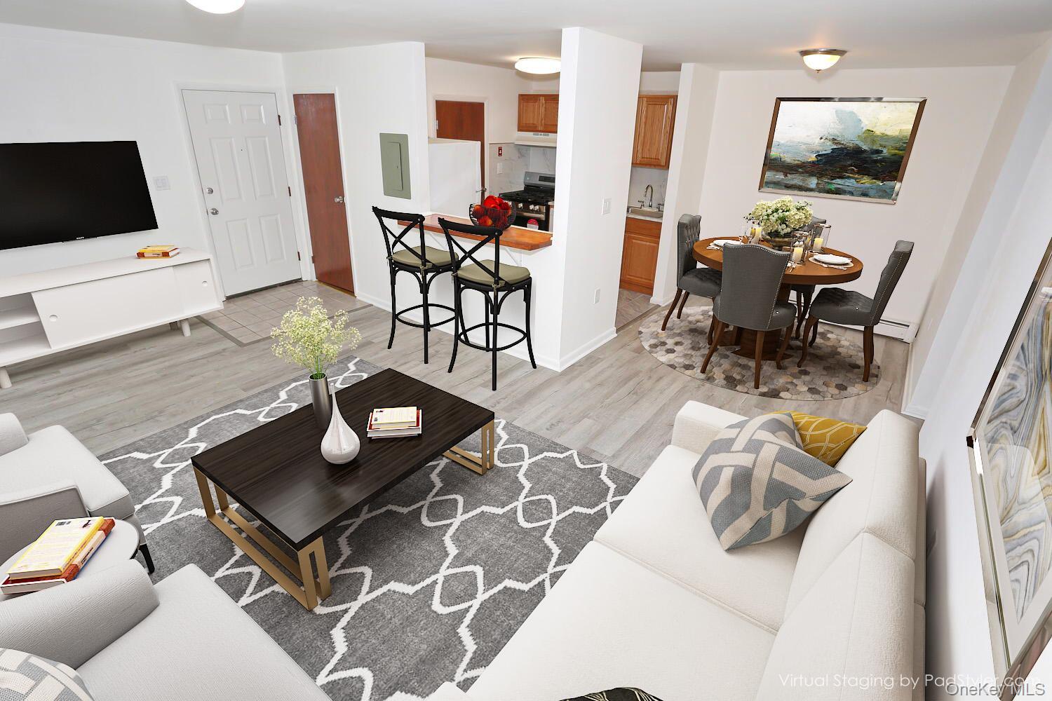 Living area featuring light wood-style flooring, baseboards, and electric panel