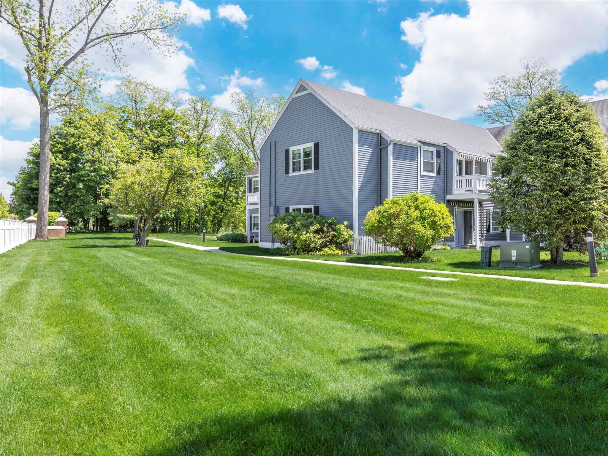 View of side of home featuring a lawn and a shingled roof