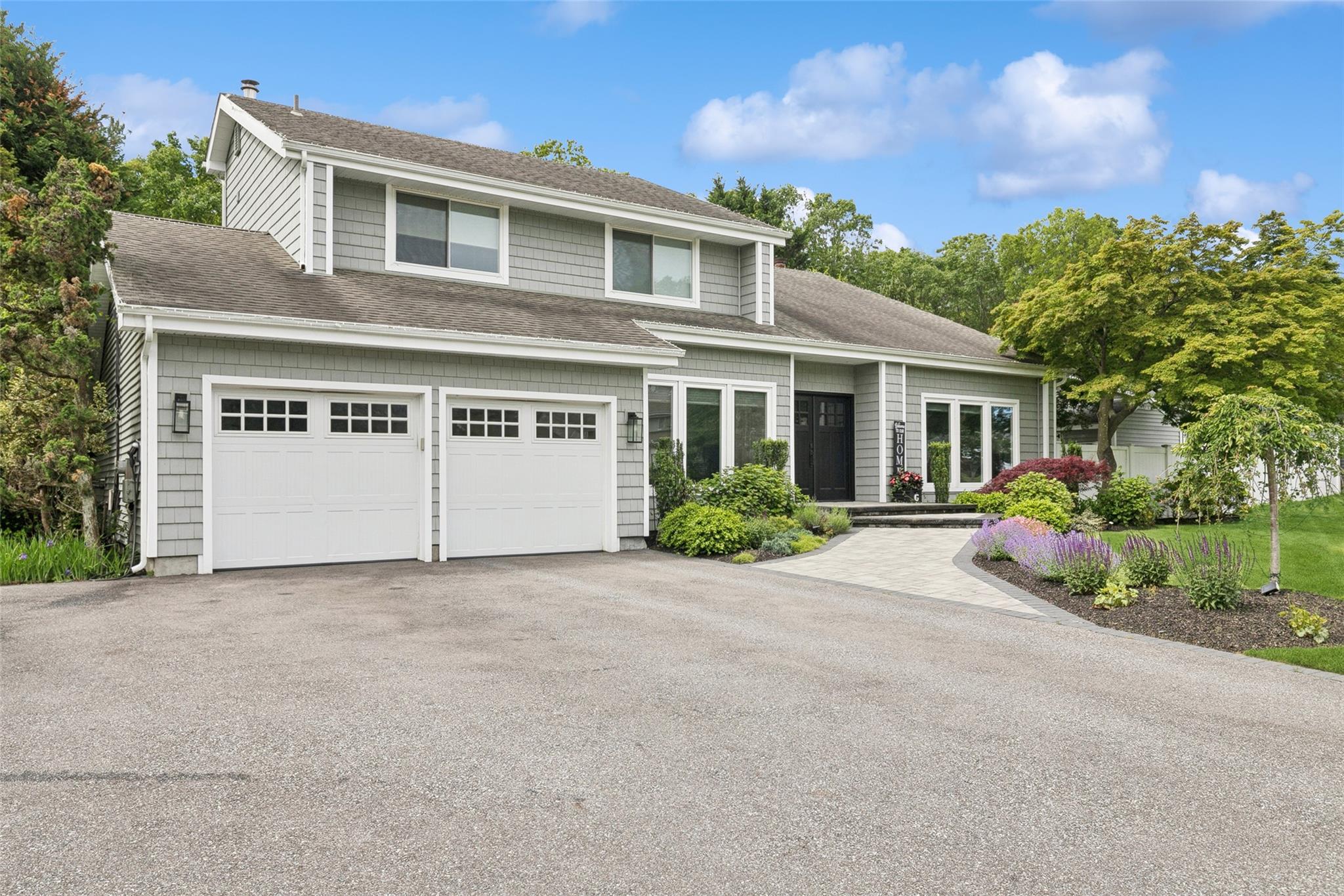 View of front facade featuring extended driveway and 2 car garage.