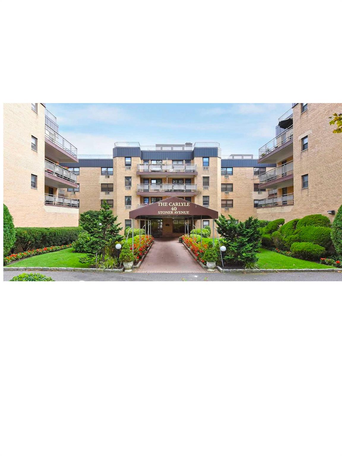 View of apartment building / complex featuring covered parking