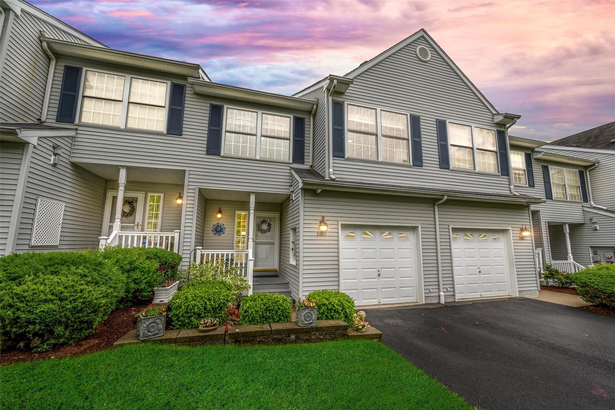 Multi unit property with asphalt driveway, covered porch, and an attached garage
