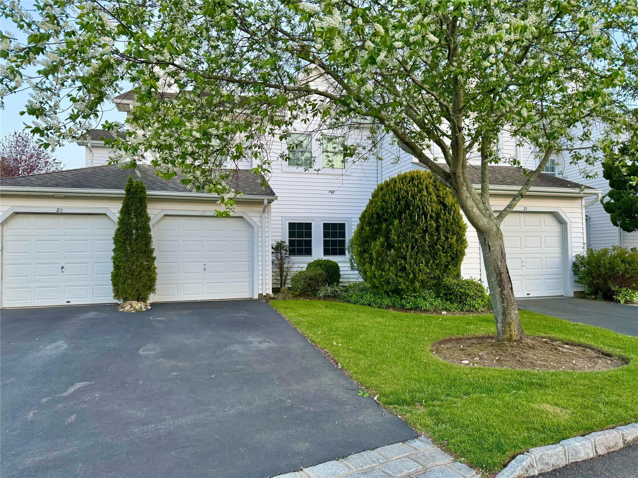 View of front of home featuring a front lawn, asphalt driveway, and roof with shingles