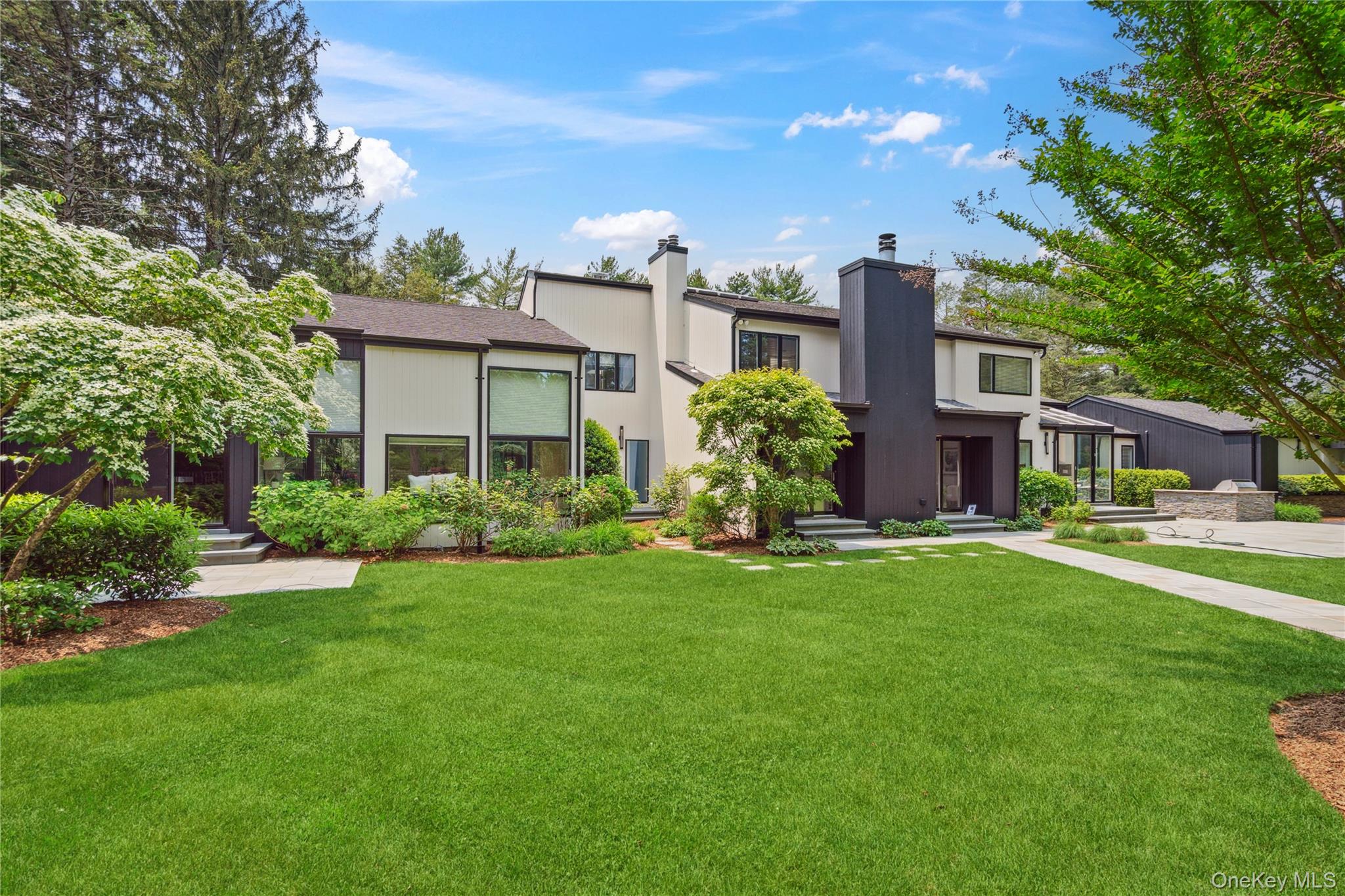View of front of property with a chimney and a front lawn
