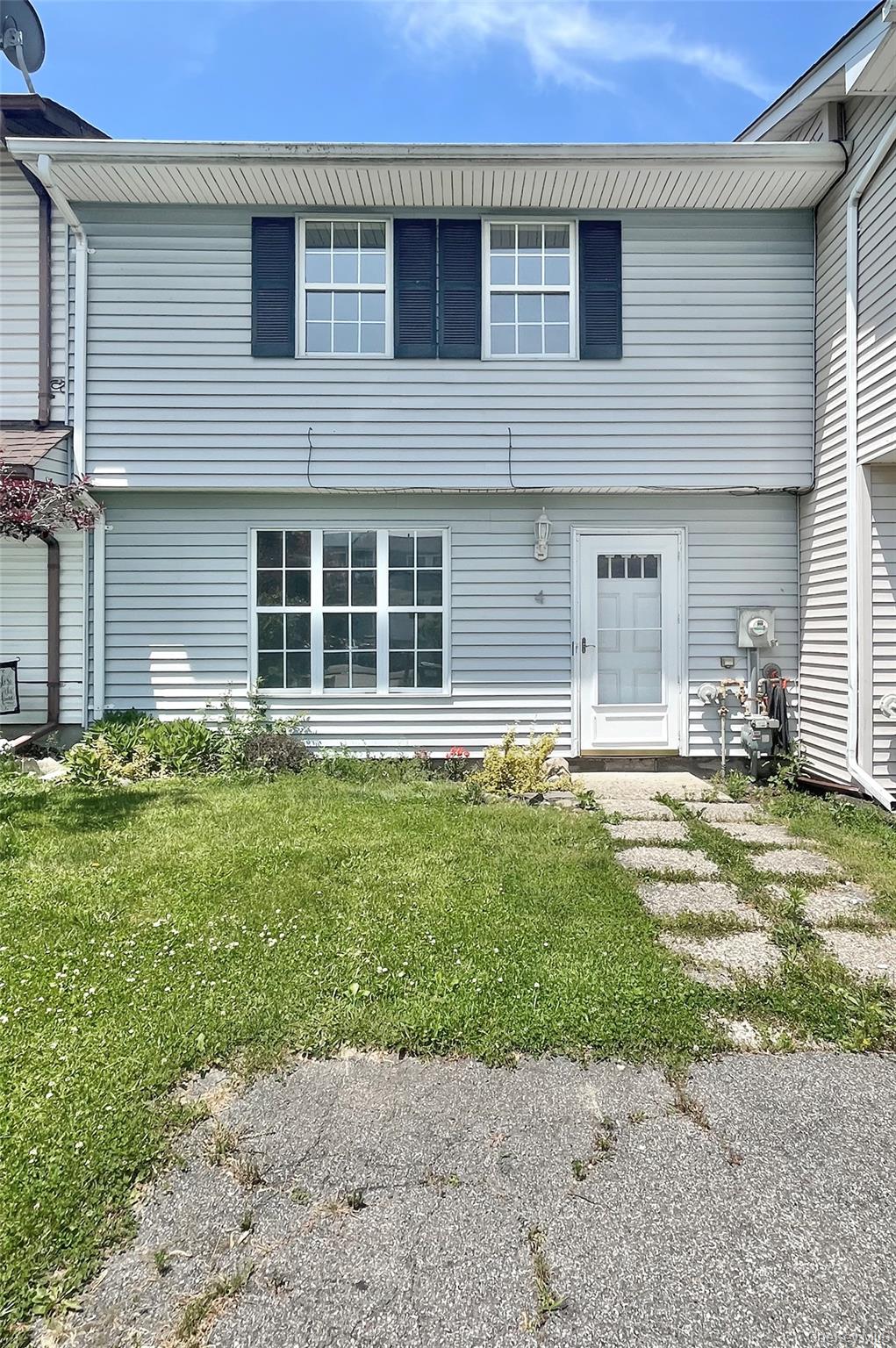 Back of property with a lawn