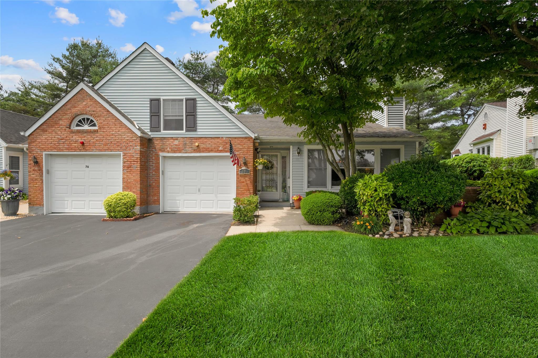 View of front of house with driveway, a garage, a front yard, and brick siding
