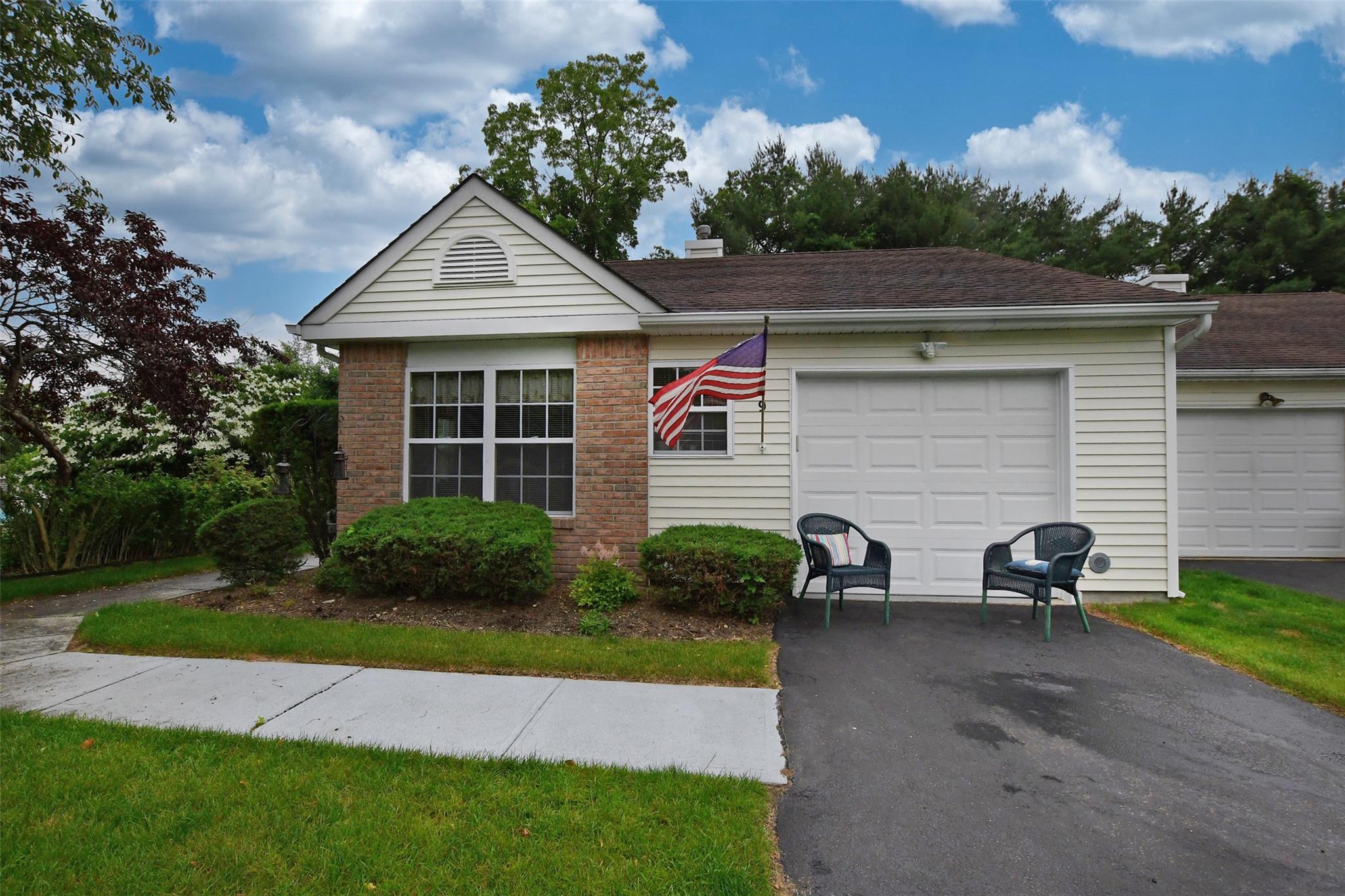 Ranch-style home featuring asphalt driveway, a chimney, and an attached garage