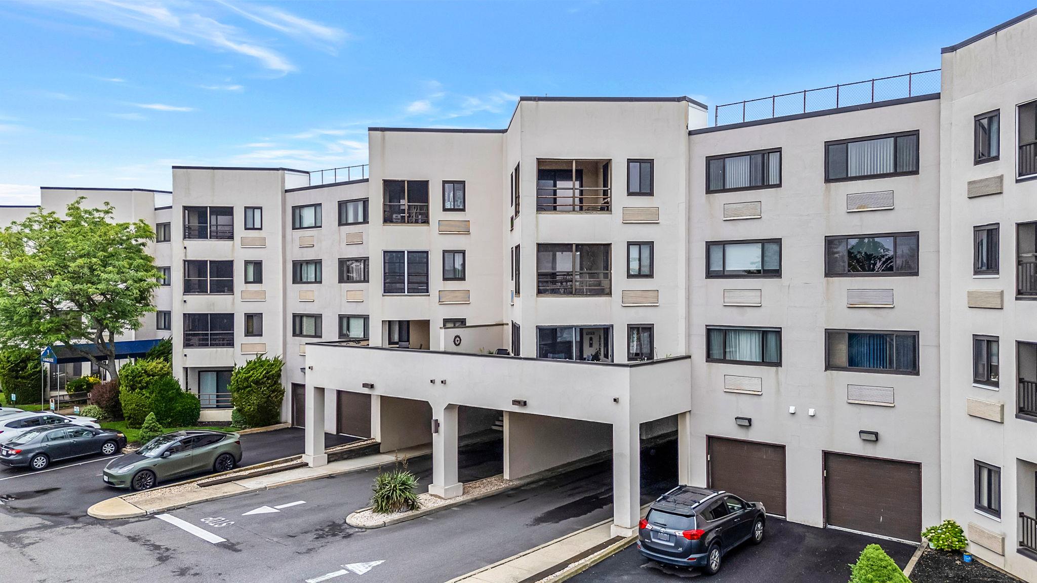 View of apartment building / complex featuring uncovered parking