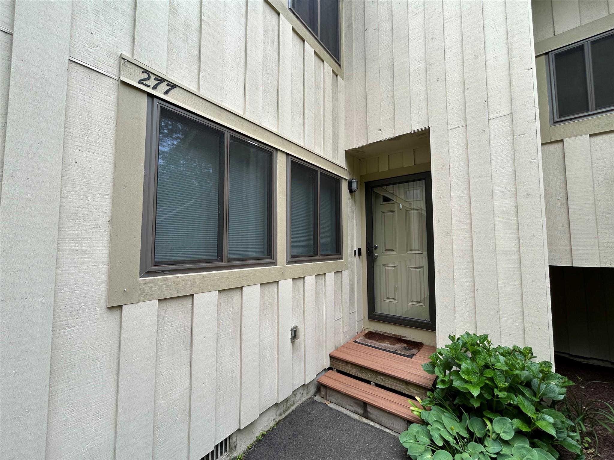 Doorway to property featuring board and batten siding