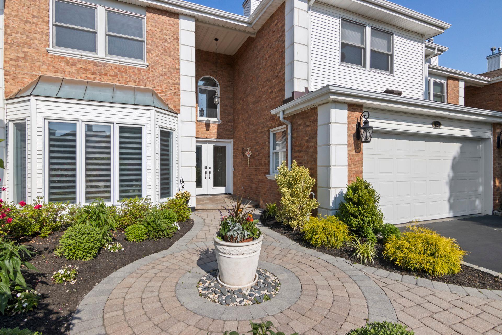 View of front of home featuring french doors, brick siding, an attached garage, and driveway