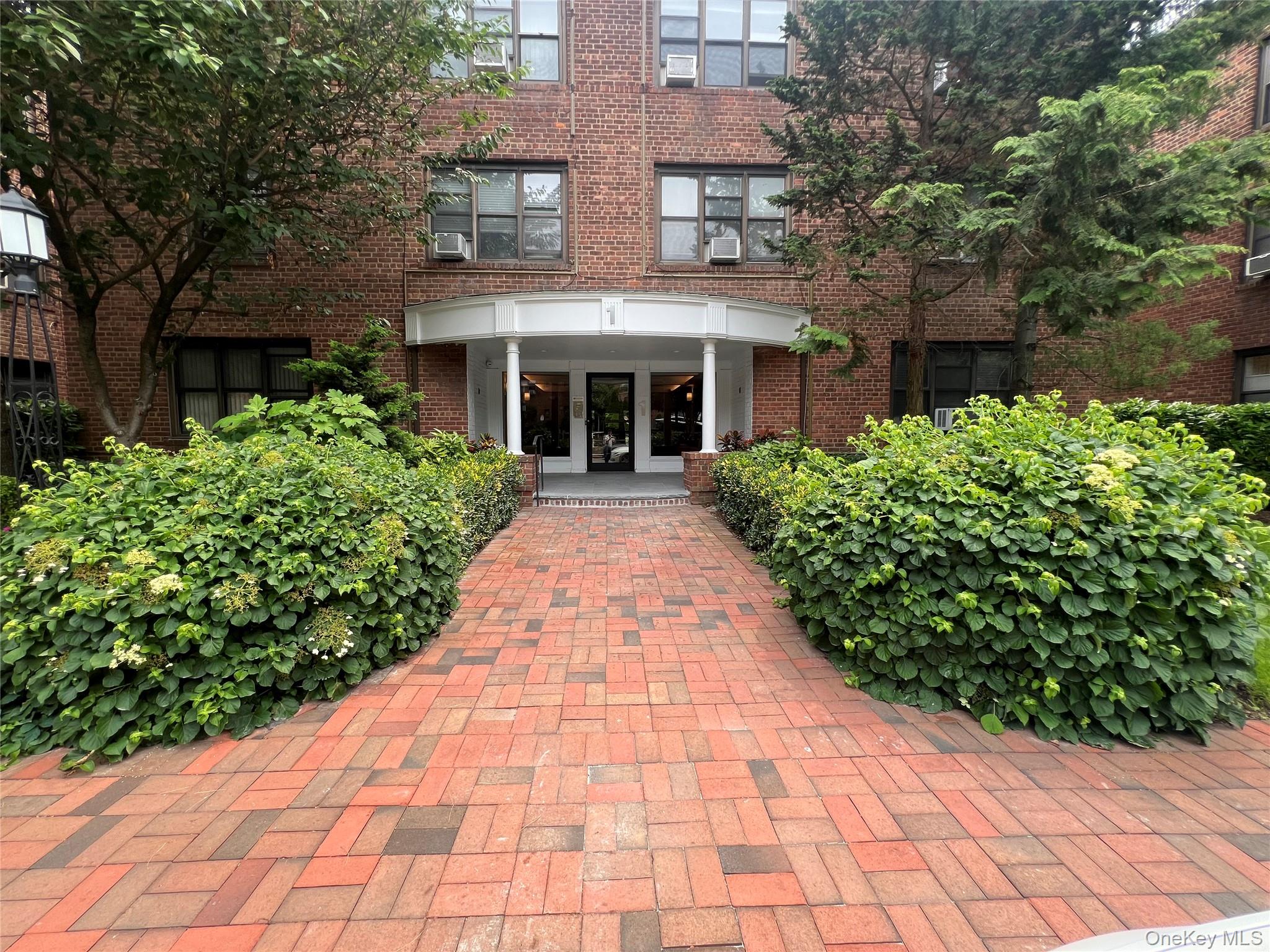 Entrance to property featuring brick siding, french doors, and cooling unit