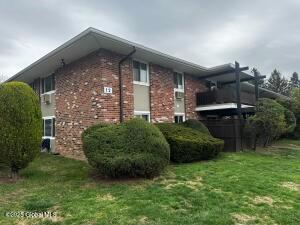View of side of home with a yard and brick siding