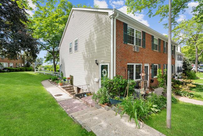 View of property exterior with a yard and brick siding