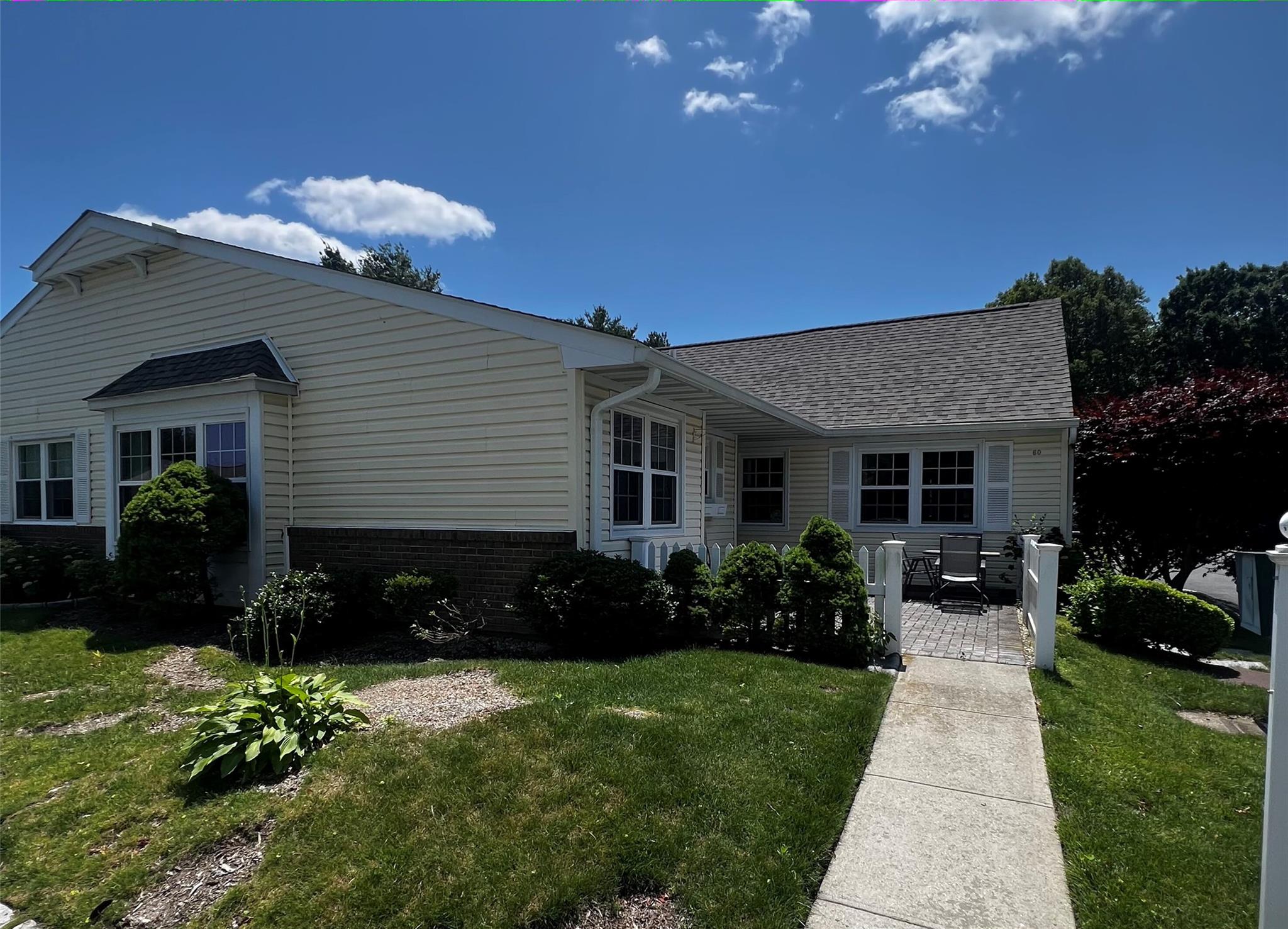 View of front of home featuring a front yard, roof with shingles, and brick siding