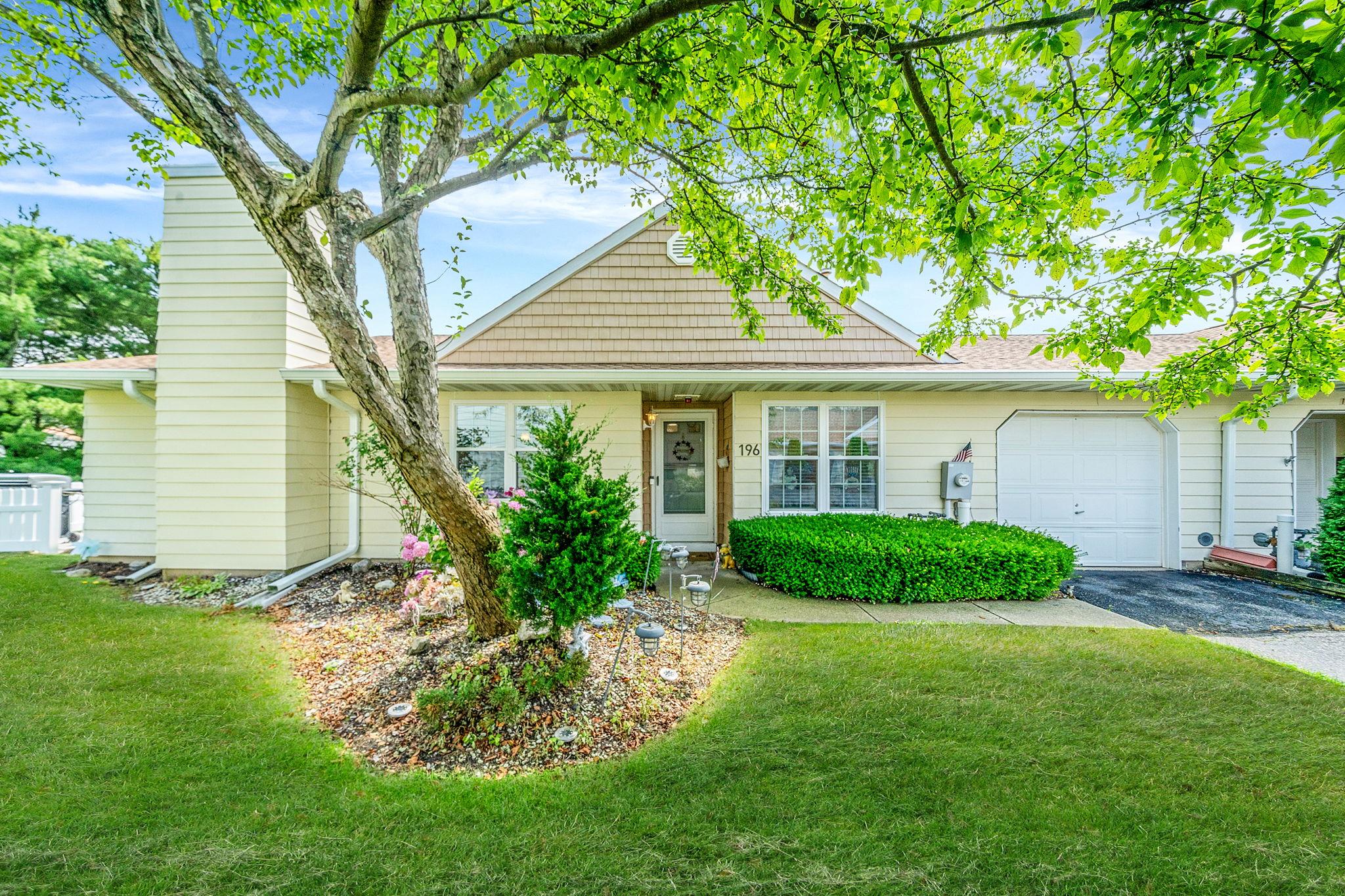 View of front of property with asphalt driveway, a garage, and a front yard