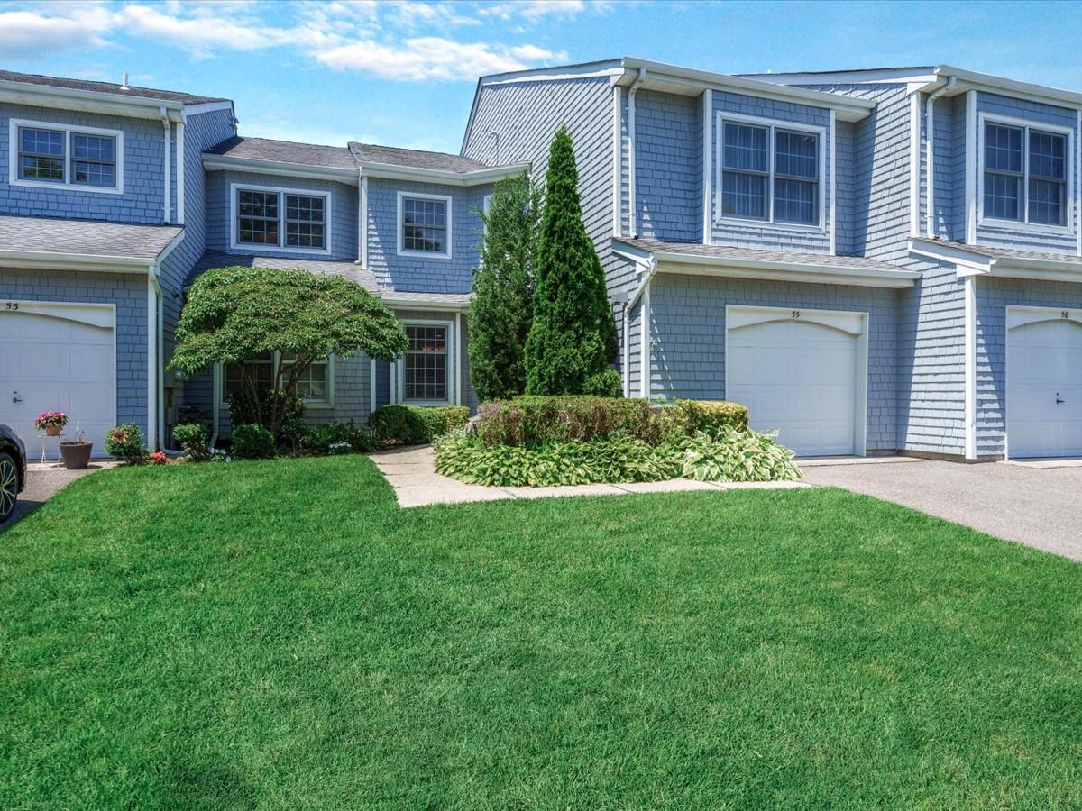View of front of house featuring a garage, a front lawn, and concrete driveway
