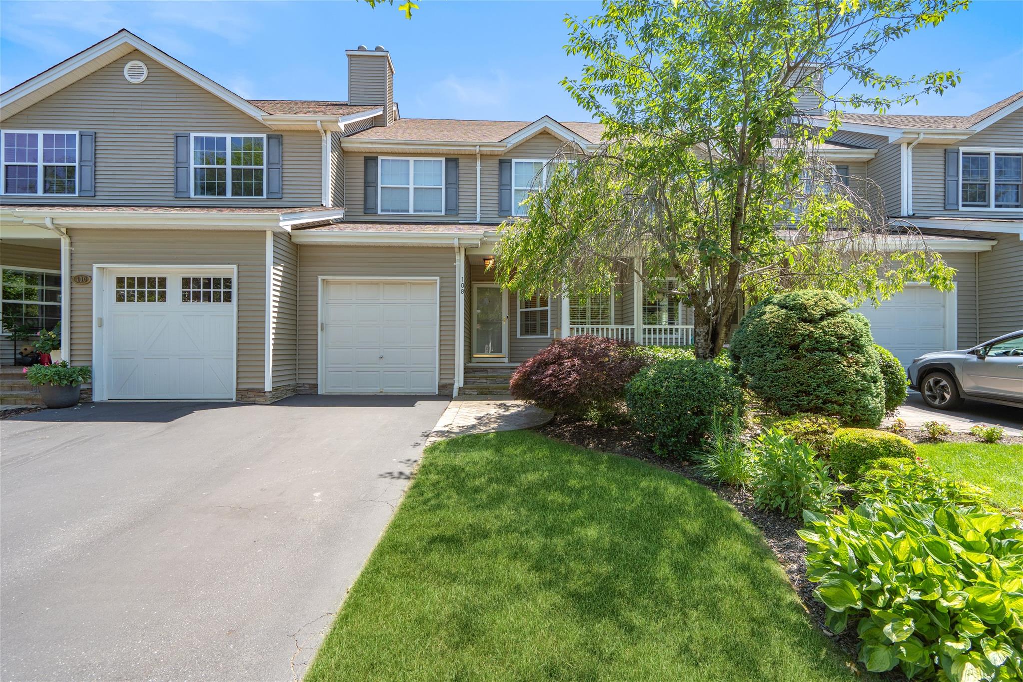Townhome / multi-family property with concrete driveway, a garage, a chimney, and roof with shingles
