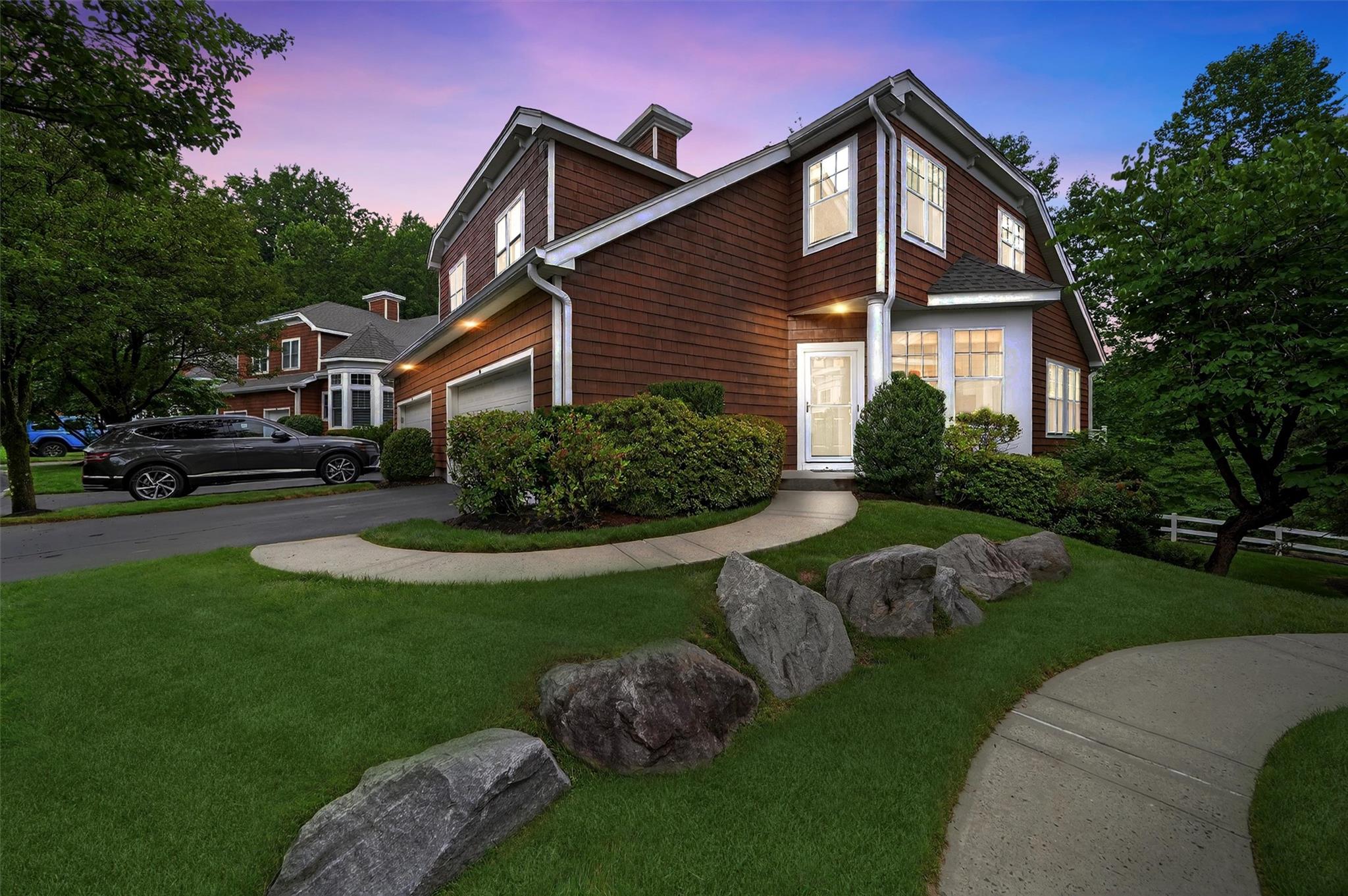 Virtual Nigh View of front facade featuring a garage, a yard, and driveway