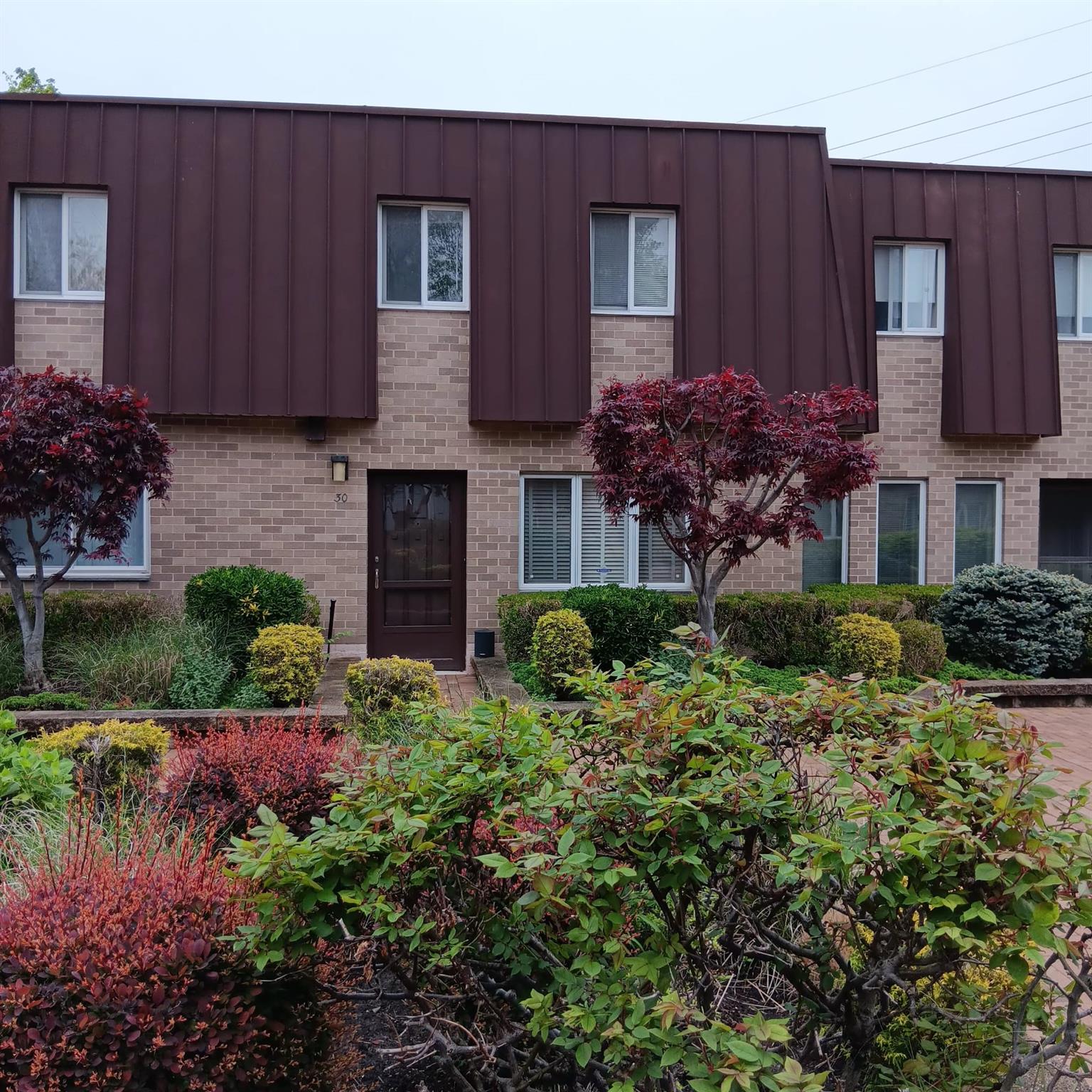 View of front of home featuring brick siding and board and batten siding