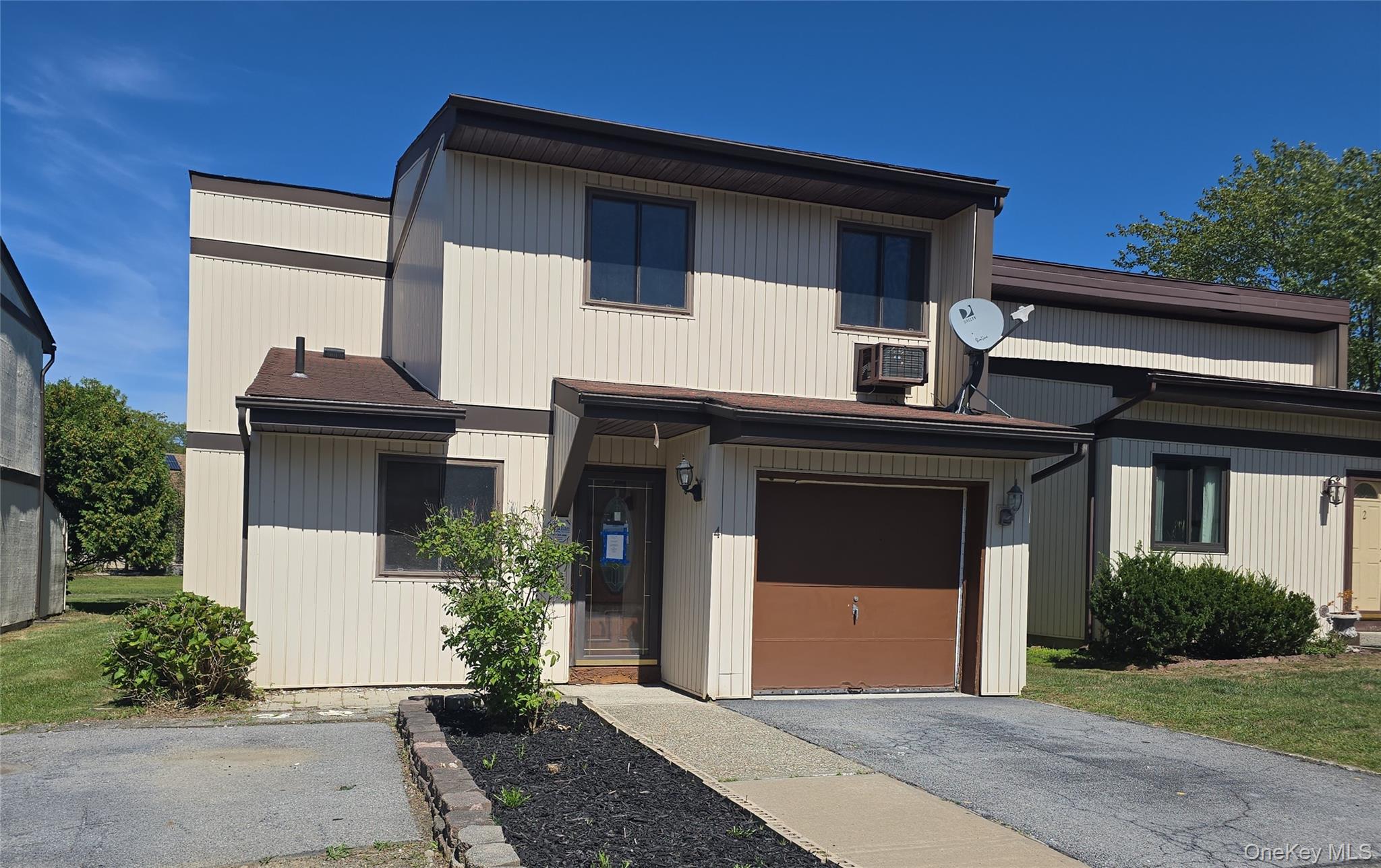 View of front of property featuring driveway and an attached garage