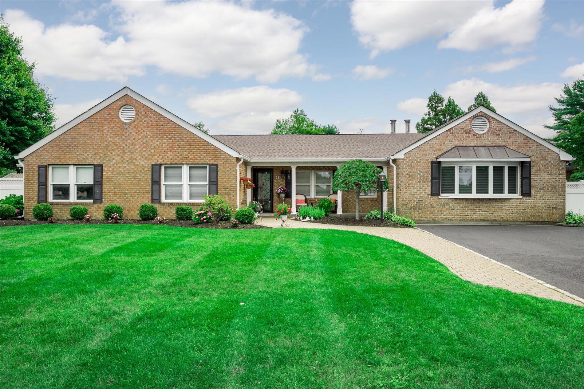 Ranch-style house with brick siding and a front lawn